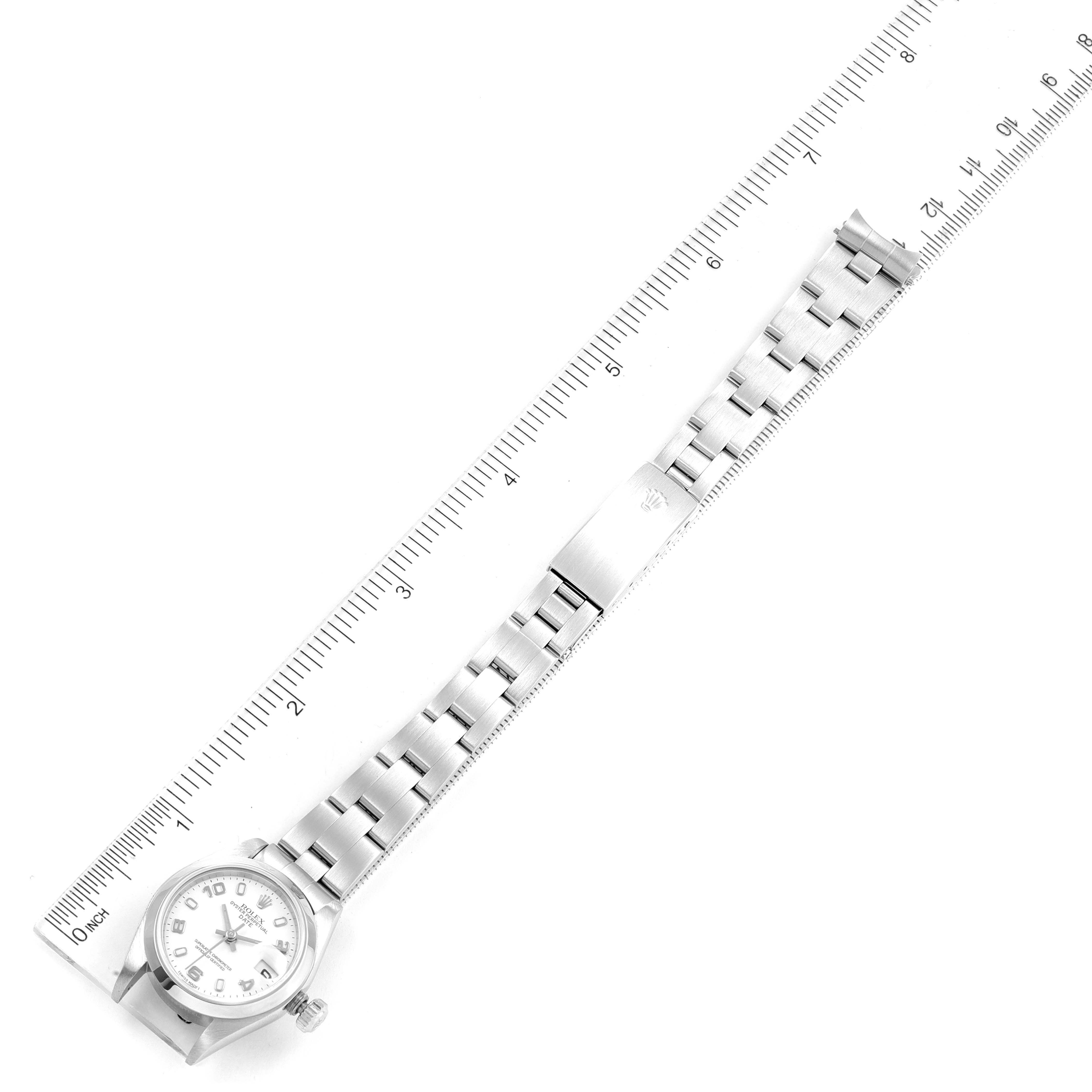 The image shows a top-down view of a Rolex Date 79160 Women's Stainless Steel White Dial 79160 Women's Stainless Steel White Dial model watch with its linked bracelet extended alongside a ruler.