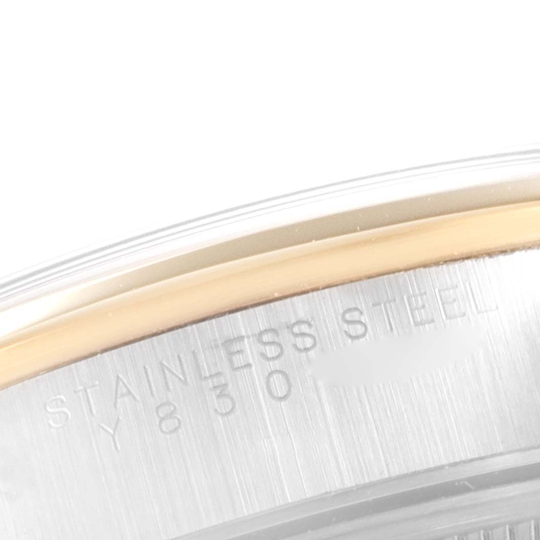 This image shows a close-up angle of the stainless steel case back of a Rolex Date 15203 Men's Steel and Gold (two tone) Black Dial 15203 Men's Steel and Gold (two tone) Black Dial model watch, highlighting part of its edge.