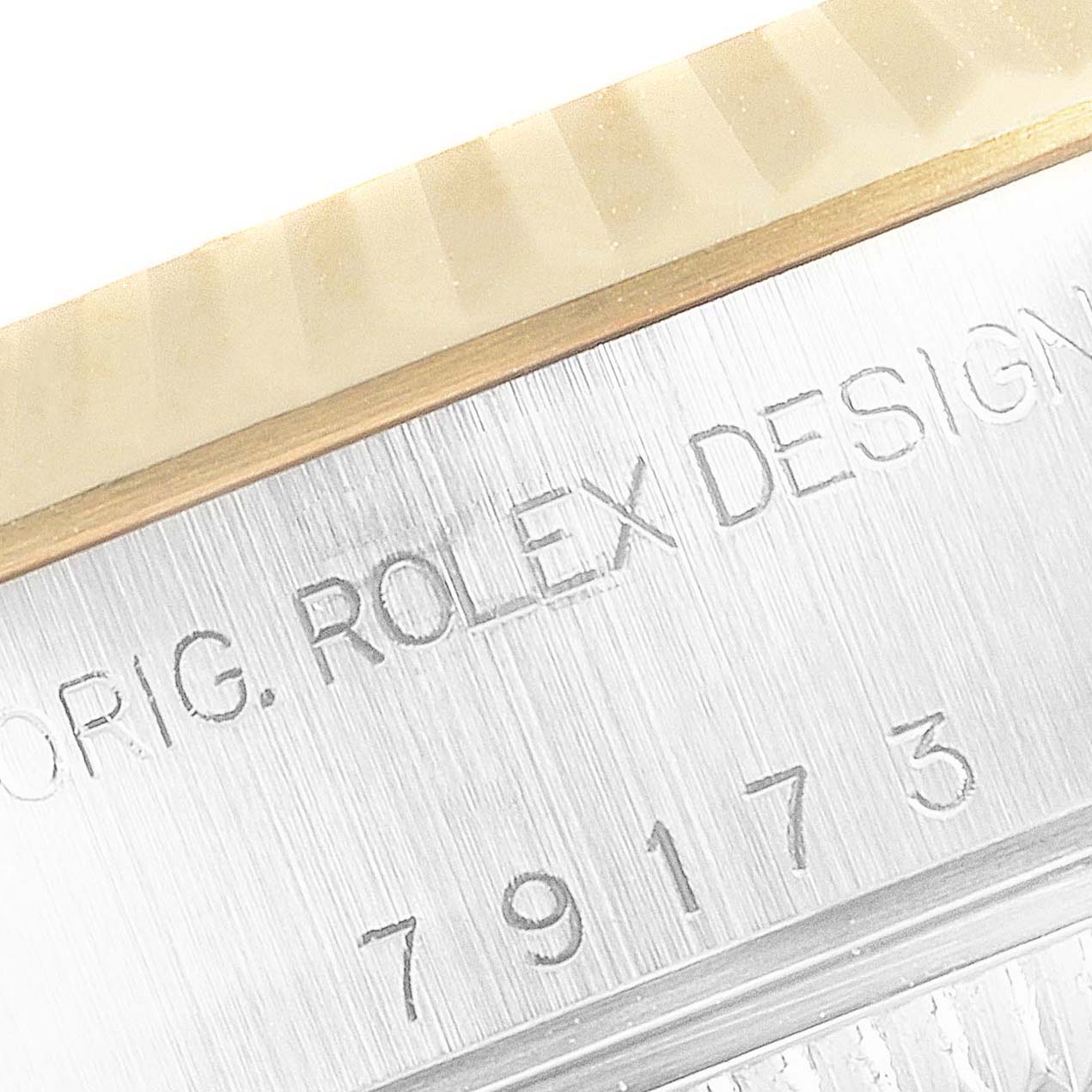 This is a close-up of the engraved serial number and "Rolex Design" text on the side of a Rolex Datejust 79173 Women's Steel and Gold (two tone) Champagne Dial 79173 Women's Steel and Gold (two tone) Champagne Dial watch.