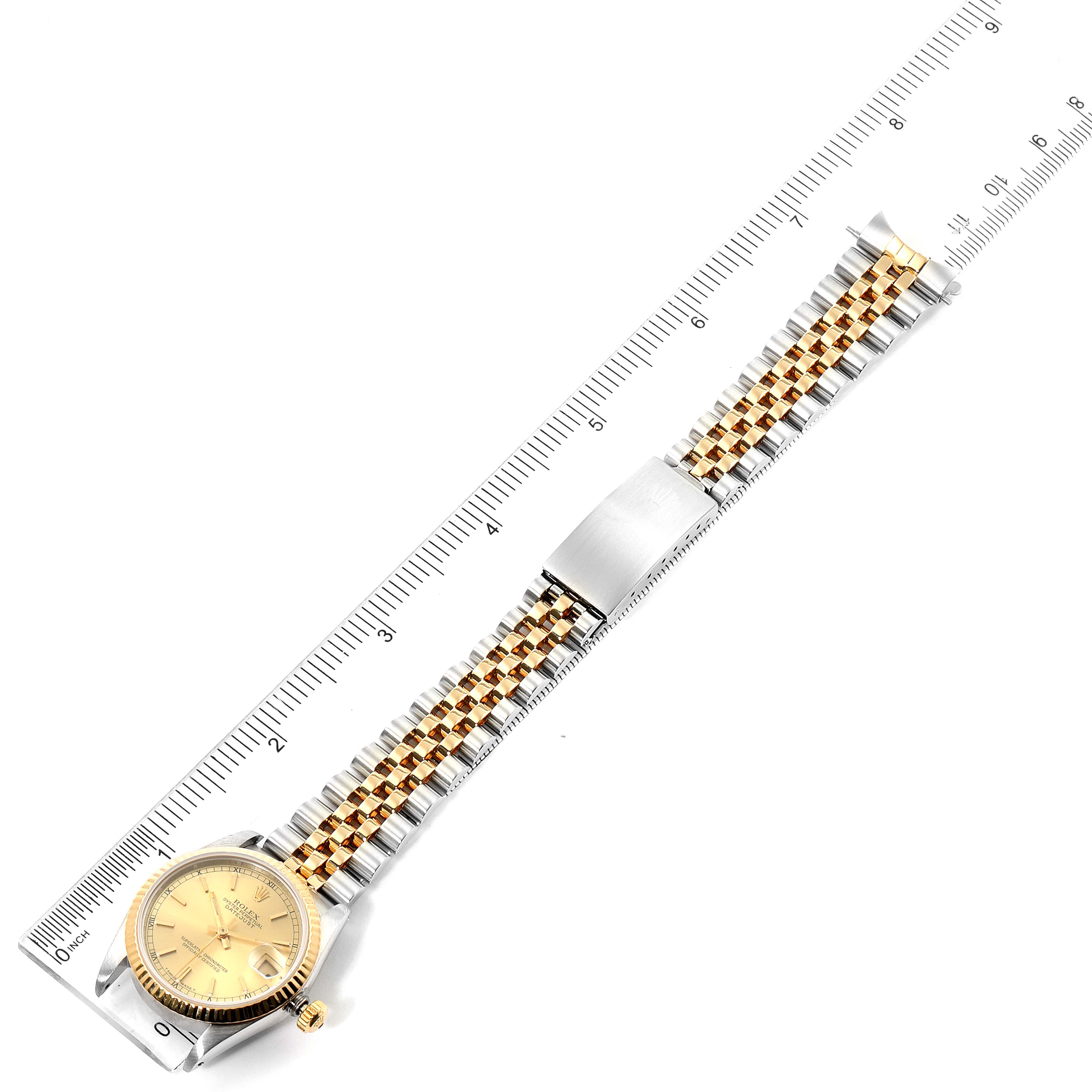 The Rolex Mid-Size 68273 Women's Steel and Gold (two tone) Champagne Dial 68273 Women's Steel and Gold (two tone) Champagne Dial watch is shown from a top-down angle, featuring the dial, bezel, case, and two-tone bracelet alongside a ruler.