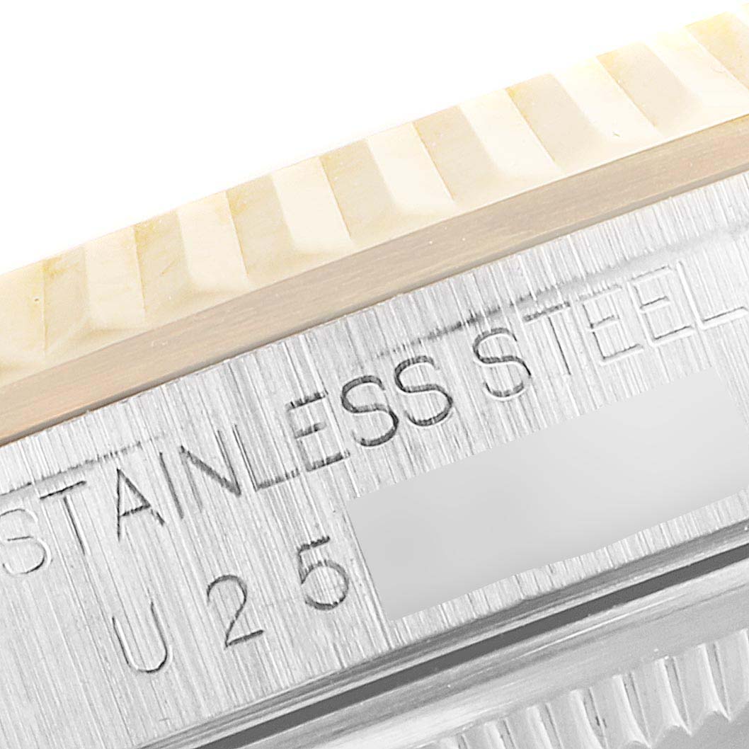 This close-up image of a Rolex Datejust 16233 Men's Steel and Gold (two tone) Silver Dial 16233 Men's Steel and Gold (two tone) Silver Dial watch shows the fluted bezel and stainless steel case engraving.