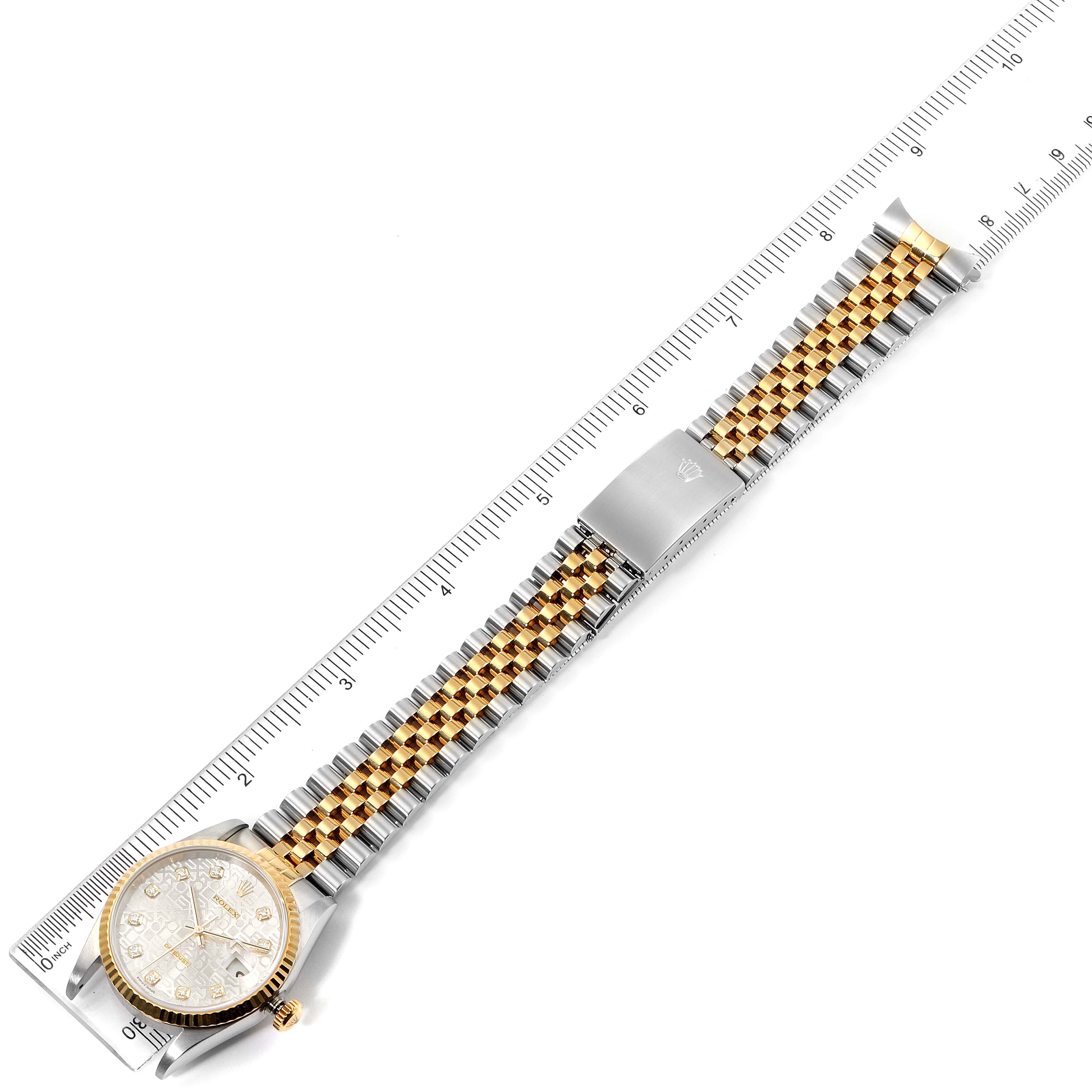 The Rolex Datejust 16233 Men's Steel and Gold (two tone) Silver Dial 16233 Men's Steel and Gold (two tone) Silver Dial watch is shown from a top-down angle with its case, dial, and jubilee bracelet aligned with a ruler for scale.