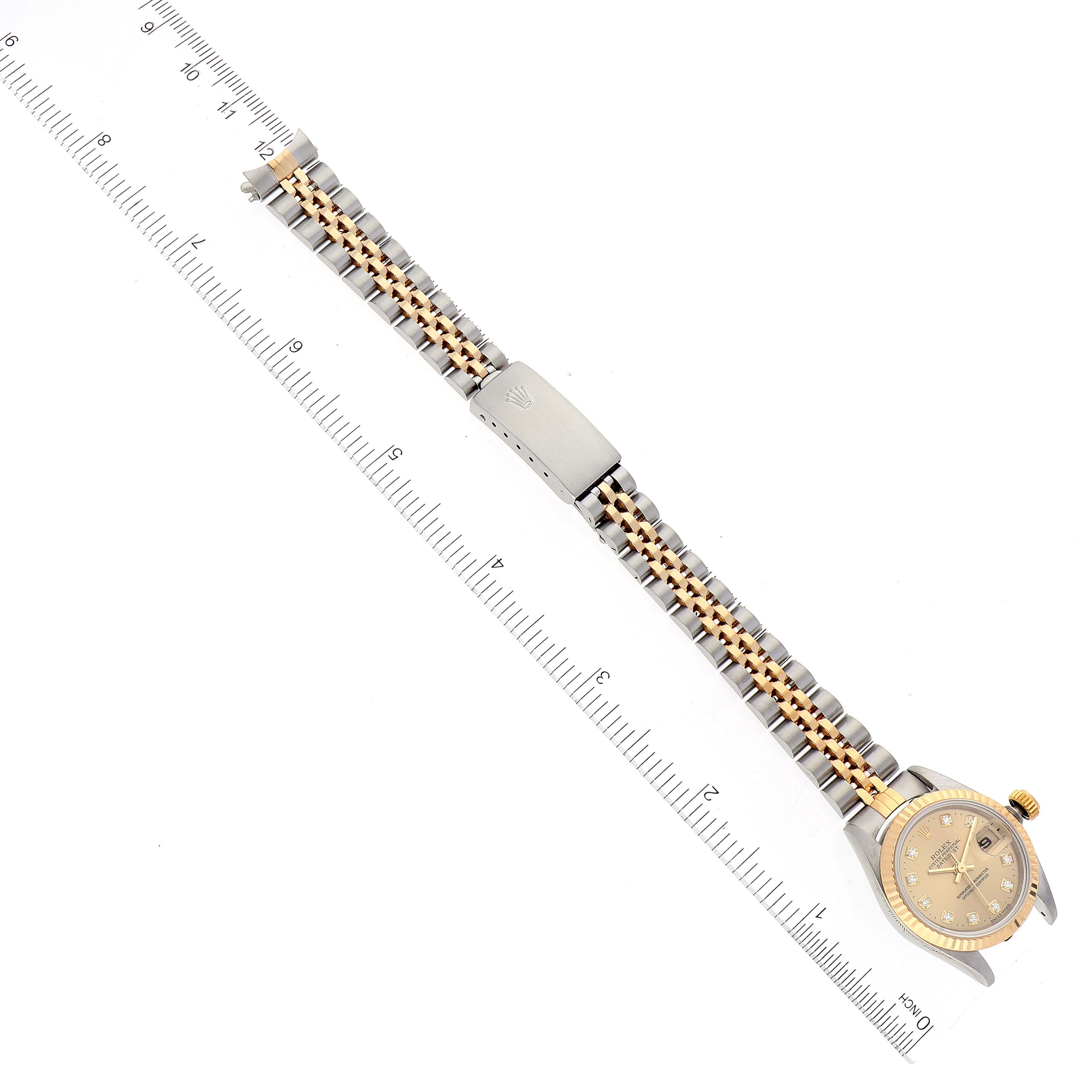 This image shows a top-down view of a Rolex Datejust 69173 Women's Steel and Gold (two tone) Champagne Dial 69173 Women's Steel and Gold (two tone) Champagne Dial watch with its bracelet next to a ruler for scale.