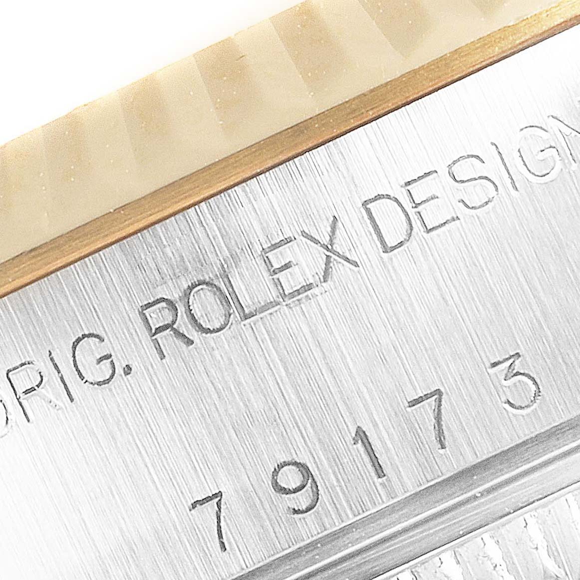 The image shows a close-up of the serial number and "ROLEX DESIGN" engraving on the side of a Rolex Datejust 79173 Women's Steel and Gold (two tone) Mother of Pearl Dial 79173 Women's Steel and Gold (two tone) Mother of Pearl Dial.