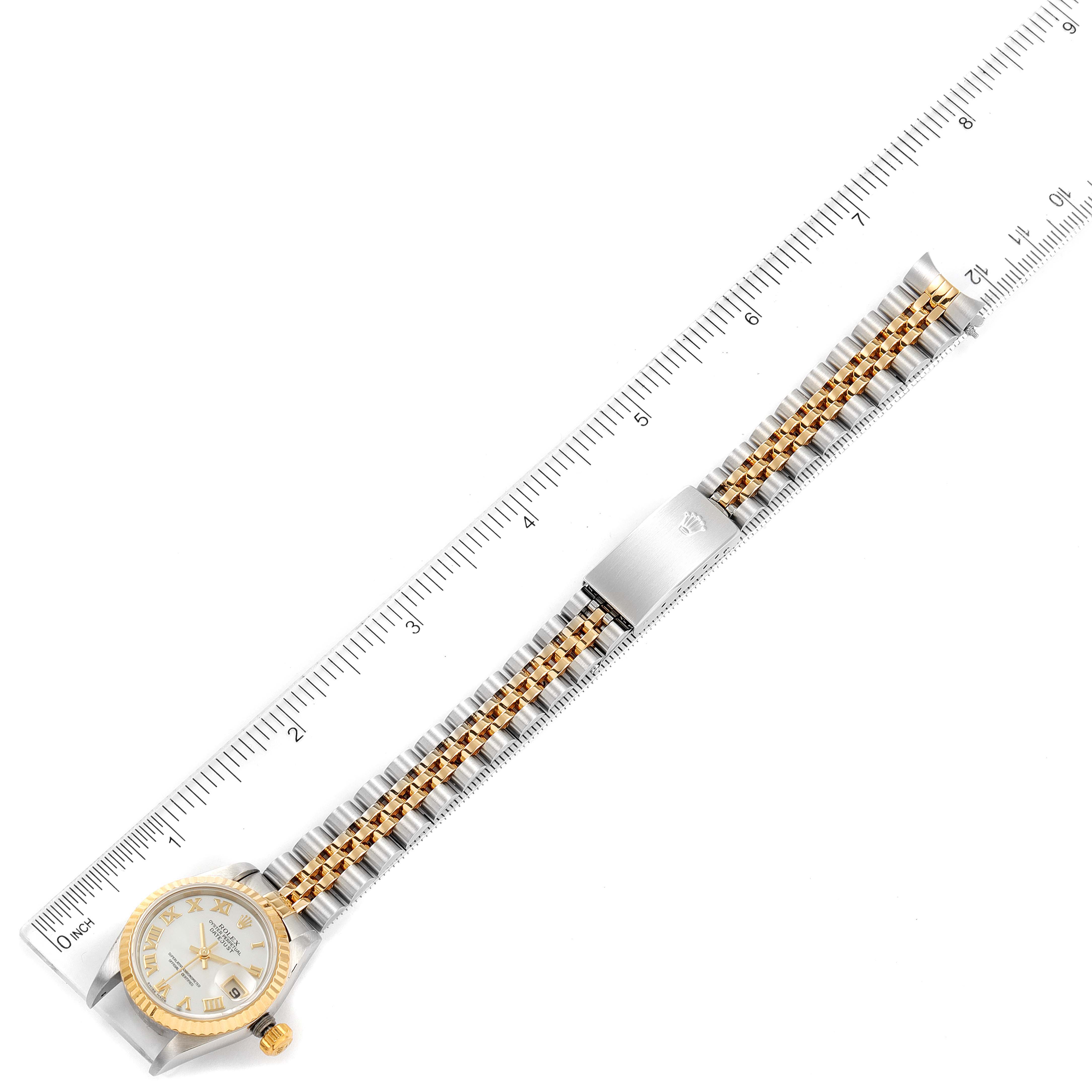 This image shows a Rolex Datejust 79173 Women's Steel and Gold (two tone) Mother of Pearl Dial 79173 Women's Steel and Gold (two tone) Mother of Pearl Dial watch laid flat beside a ruler, displaying the face, bracelet, and clasp from a top-down angle.