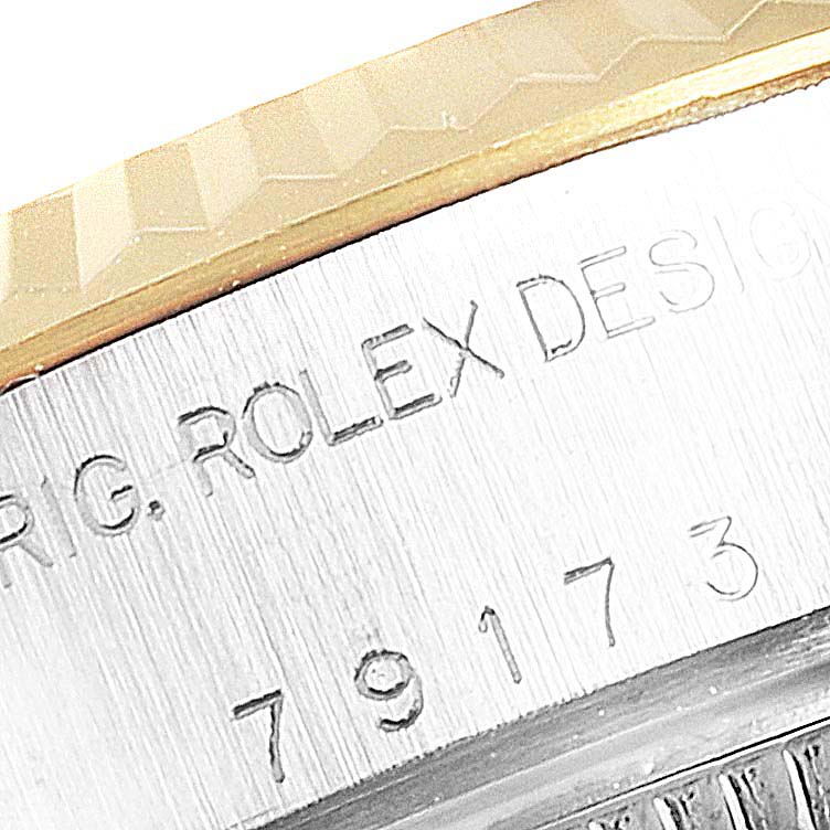 The image shows a close-up of the engraved bezel and side case of a Rolex Datejust 79173 Women's Steel and Gold (two tone) Beige Dial 79173 Women's Steel and Gold (two tone) Beige Dial watch.