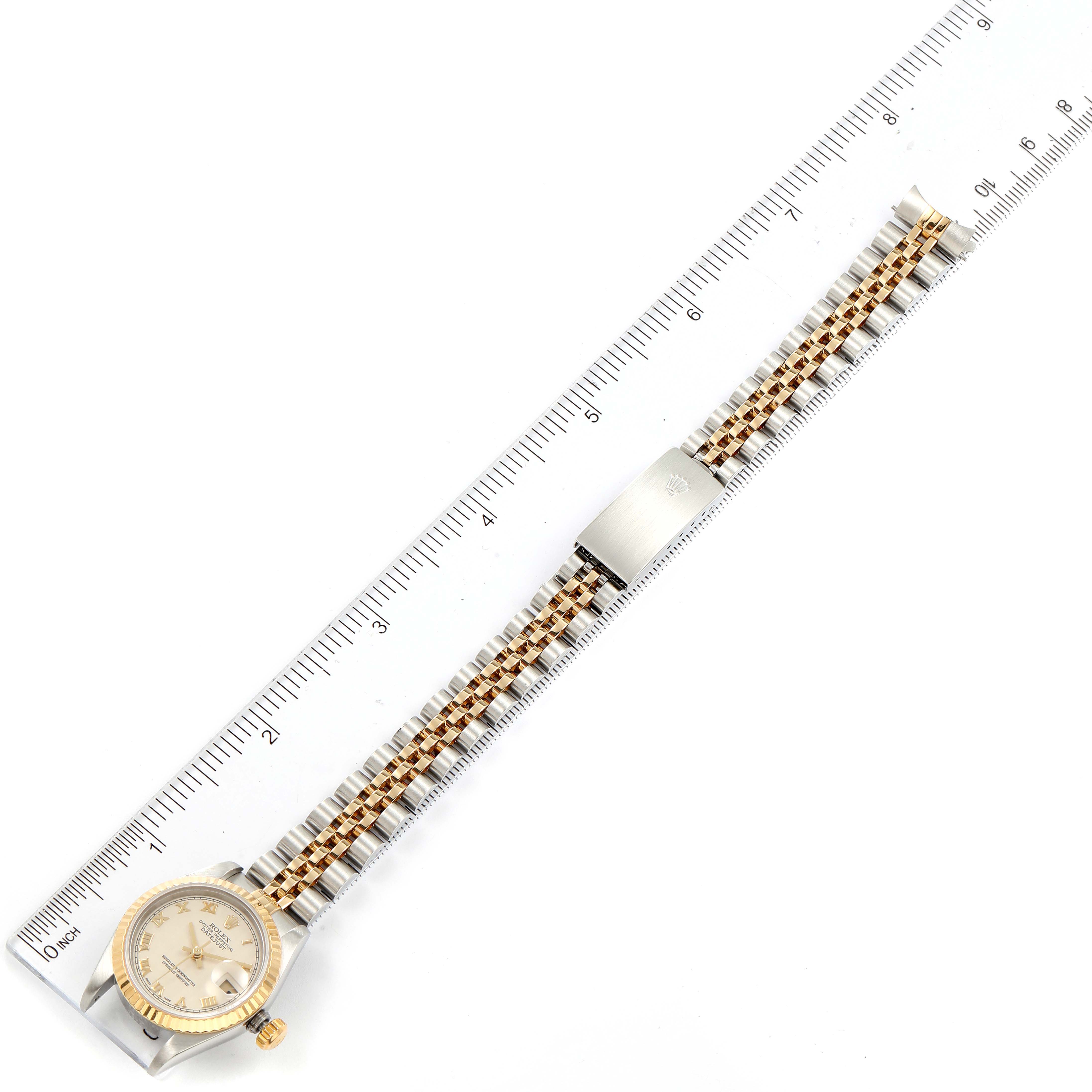 This image shows a top-down view of a Rolex Datejust 79173 Women's Steel and Gold (two tone) Beige Dial 79173 Women's Steel and Gold (two tone) Beige Dial watch with the case, dial, and bracelet fully visible, measured against a ruler.