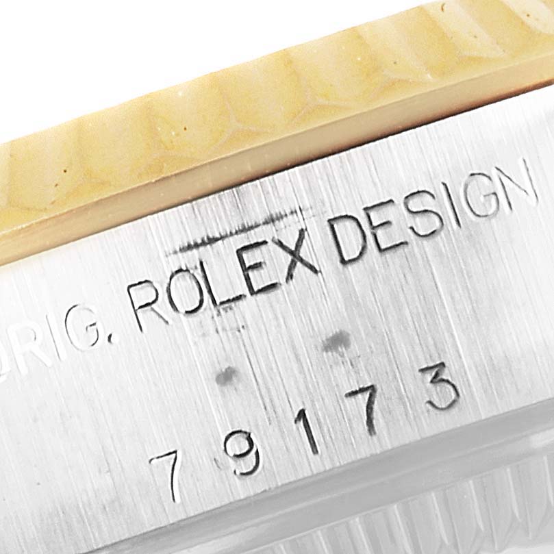 The image shows a close-up of the side of a Rolex Datejust 79173 Women's Steel and Gold (two tone) Beige Dial 79173 Women's Steel and Gold (two tone) Beige Dial watch, highlighting the engraved model number and "ROLEX DESIGN" text.
