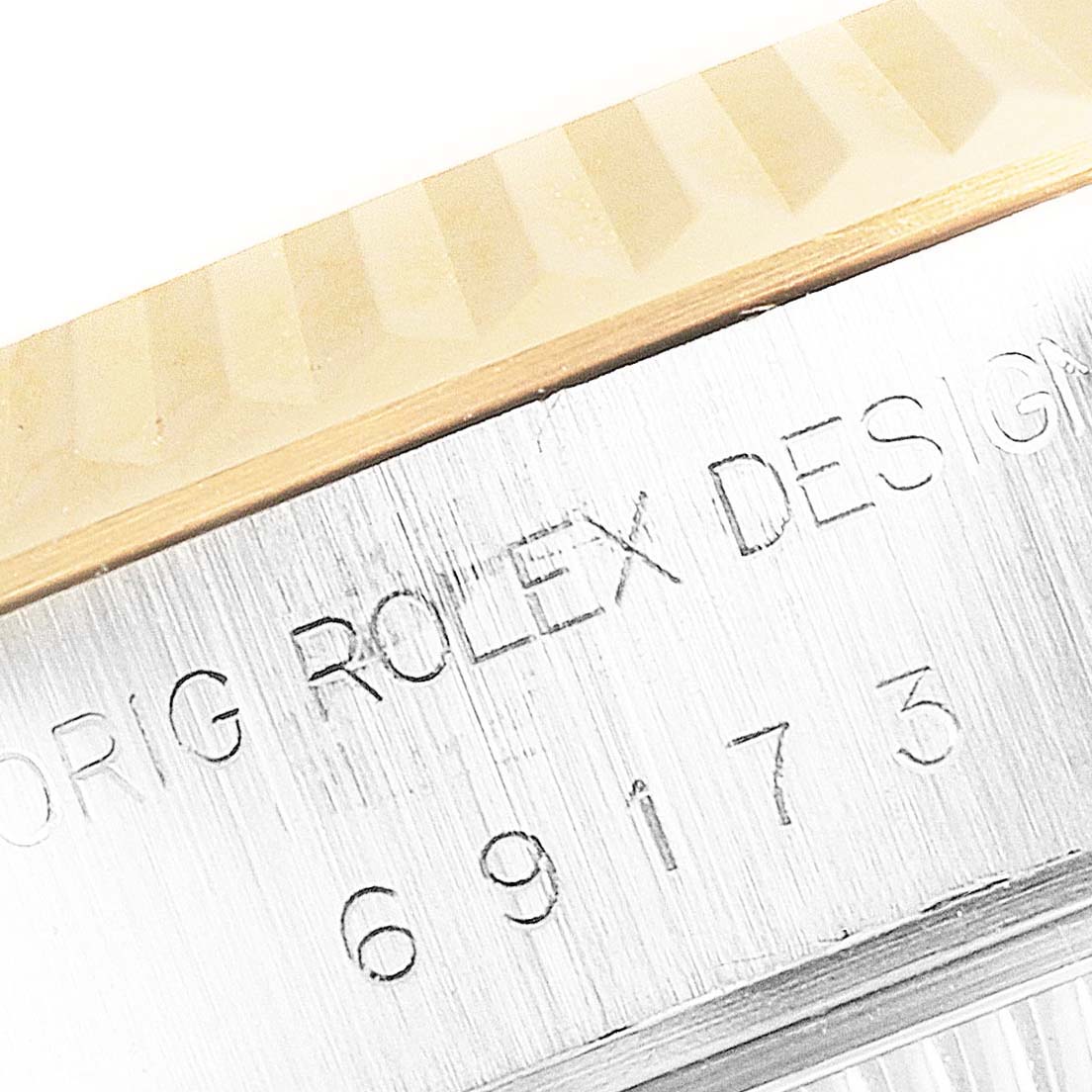 This image shows a close-up angle of the engraved details on the bezel and case of a Rolex Datejust 69173 Women's Steel and Gold (two tone) White Dial 69173 Women's Steel and Gold (two tone) White Dial watch.