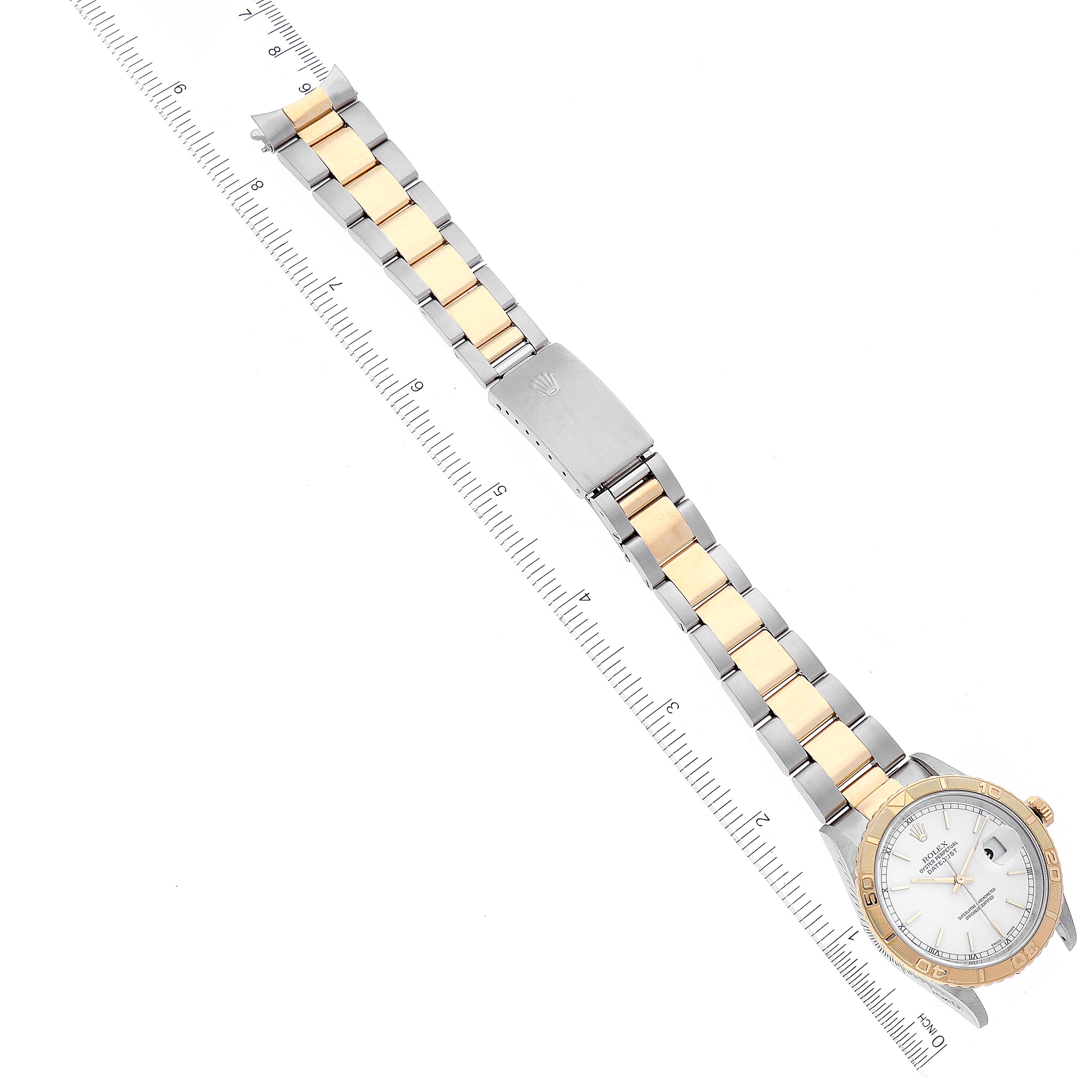 The Rolex Turn-o-Graph 16263 Men's Steel and Gold (two tone) White Dial 16263 Men's Steel and Gold (two tone) White Dial watch is displayed from a top-down angle, showing the entire bracelet and part of the face next to a ruler.