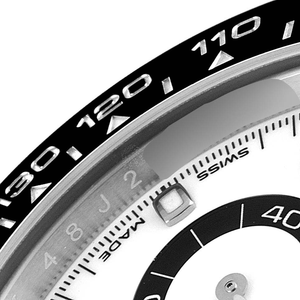 This image shows a close-up of the bezel and part of the dial of a Rolex Daytona 116500 Men's Stainless Steel White Dial 116500 Men's Stainless Steel White Dial watch.
