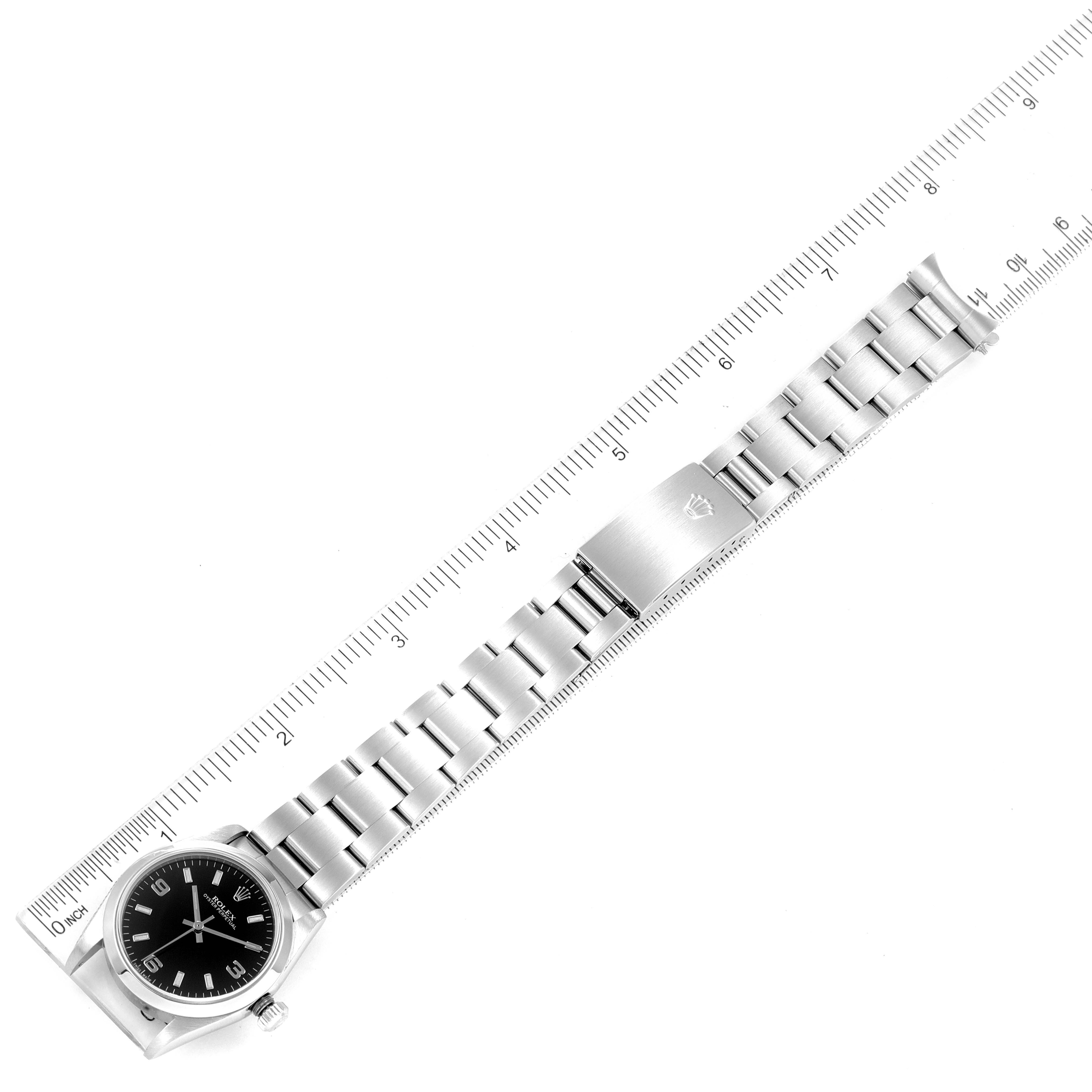 The image shows a Rolex Mid-Size 77080 Women's Stainless Steel Black Dial 77080 Women's Stainless Steel Black Dial watch laid flat with its strap extended next to a ruler for measurement.