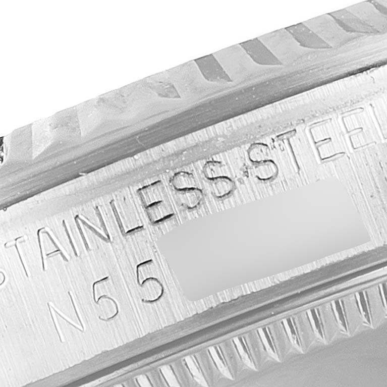 This image shows a close-up of the outer rim and engravings of a Mid-Size Rolex watch, highlighting its stainless steel composition.