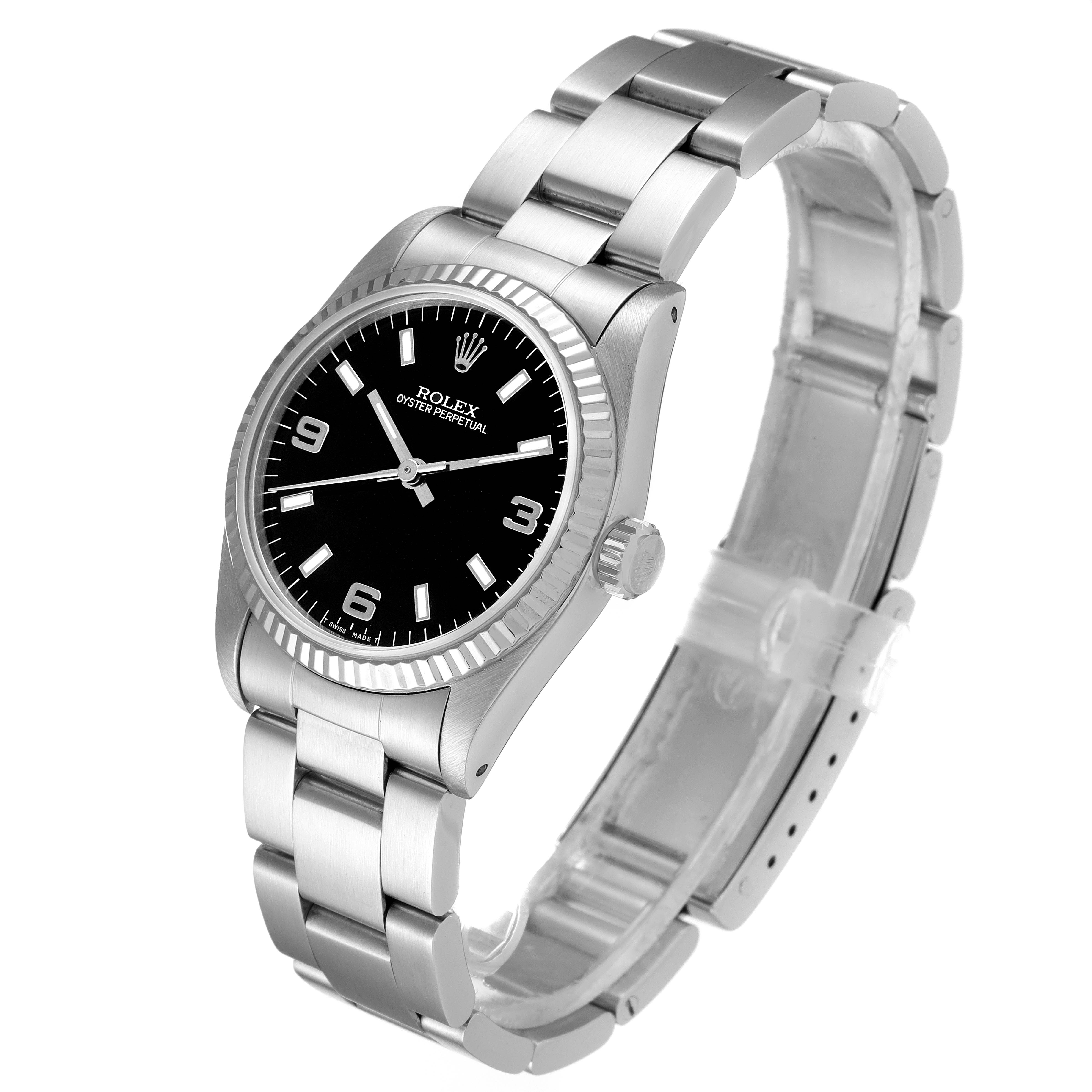 This Rolex Mid-Size 67514 Women's Stainless Steel Black Dial 67514 Women's Stainless Steel Black Dial Oyster Perpetual watch is shown at a slight angle from the front, highlighting its black dial and stainless steel bracelet.