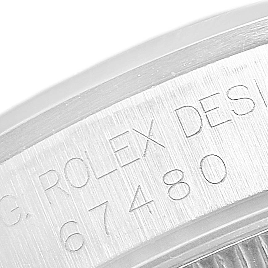 This close-up shows the engraved model number and "ROLEX DESIGN" on the side of the case of a Rolex Mid-Size 67480 Women's Stainless Steel Black Dial 67480 Women's Stainless Steel Black Dial watch.