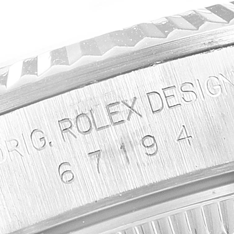 This close-up image shows the engraved text and part of the bezel of a Rolex Oyster Perpetual 67194 Women's Stainless Steel Black Dial 67194 Women's Stainless Steel Black Dial watch.