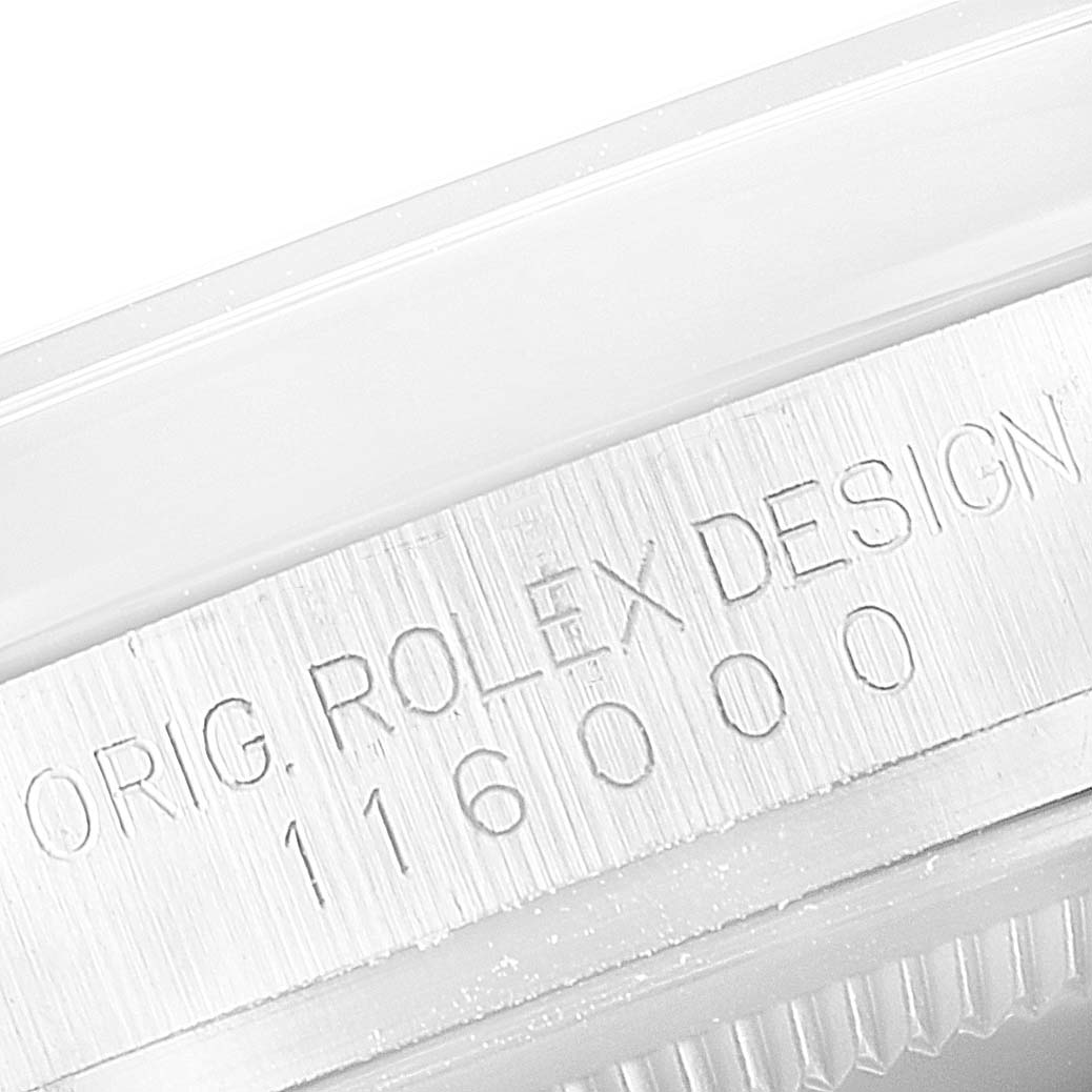 The close-up image shows the engraved side of the bezel on a Rolex Oyster Perpetual 116000 Men's Stainless Steel Burgundy Dial 116000 Men's Stainless Steel Burgundy Dial model.