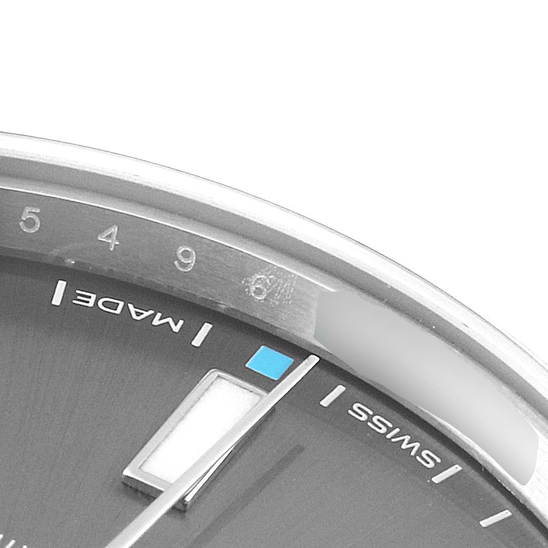 The image shows a close-up of the dial and markers of an Oyster Perpetual model by Rolex from an oblique angle.
