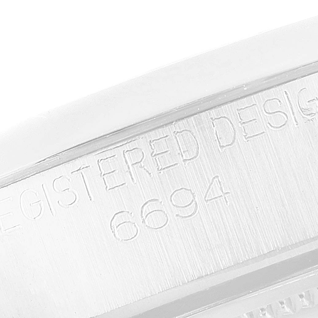 The image shows a close-up of the side engraving on a Rolex Vintage Collection 6694 Men's Stainless Steel Black Dial 6694 Men's Stainless Steel Black Dial model displaying "REGISTERED DESIGN" and "6694".