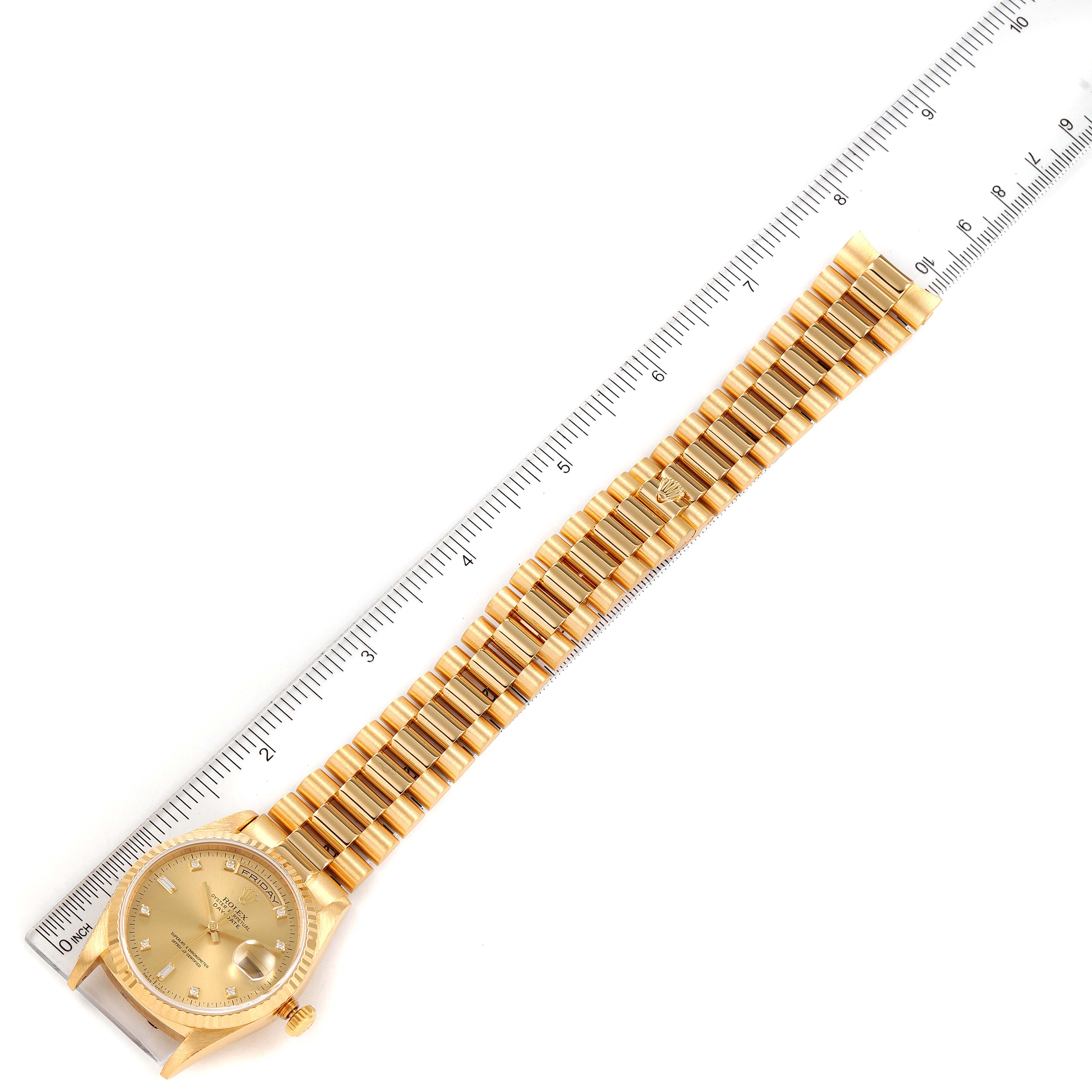 This image shows the full length of the Rolex President 18238 Men's Yellow Gold Champagne Dial 18238 Men's Yellow Gold Champagne Dial model watch, including the face, case, and bracelet, positioned alongside a ruler.