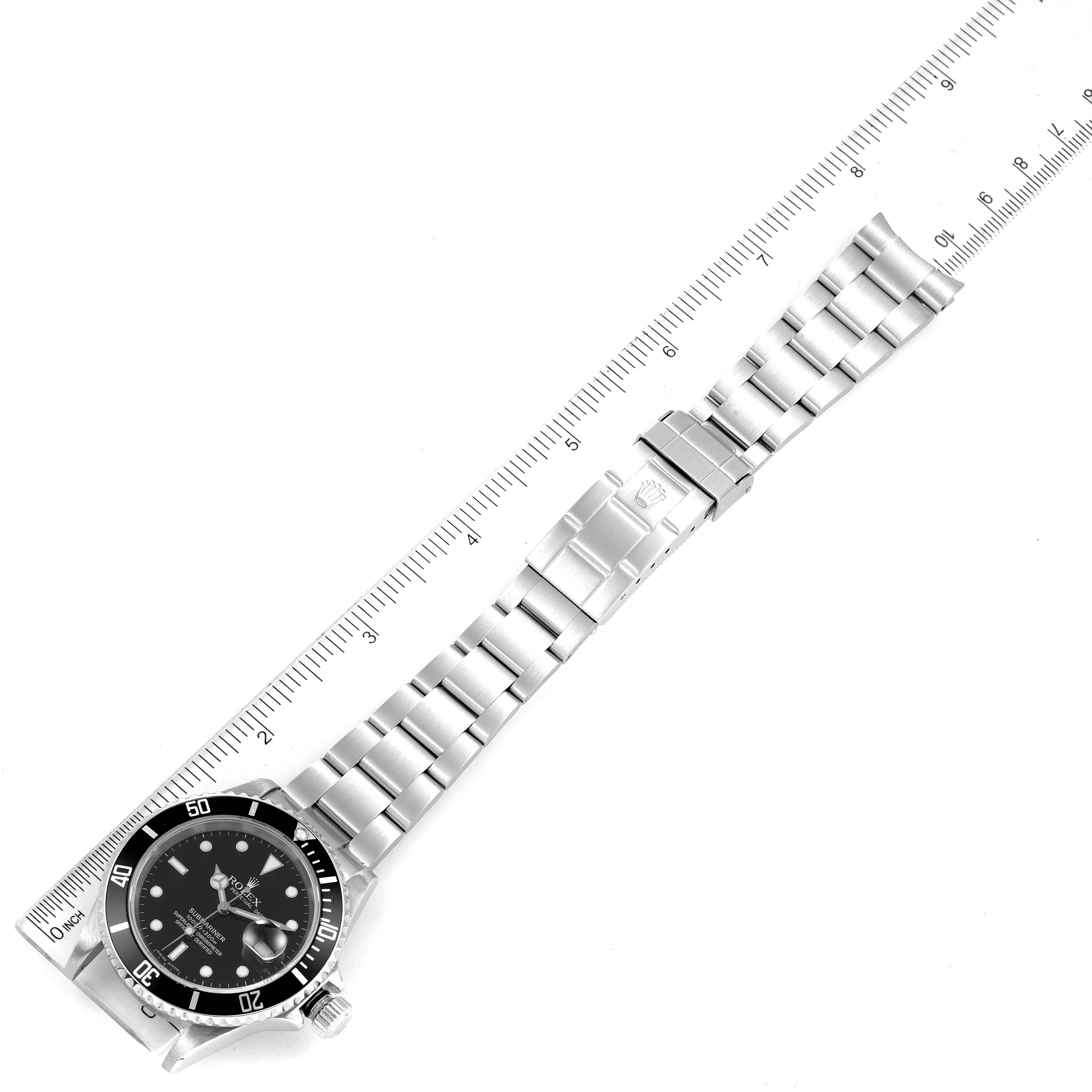 The image shows a top view of a Rolex Submariner 16610 Men's Stainless Steel Black Dial 16610 Men's Stainless Steel Black Dial watch with an extended bracelet next to a measuring ruler.
