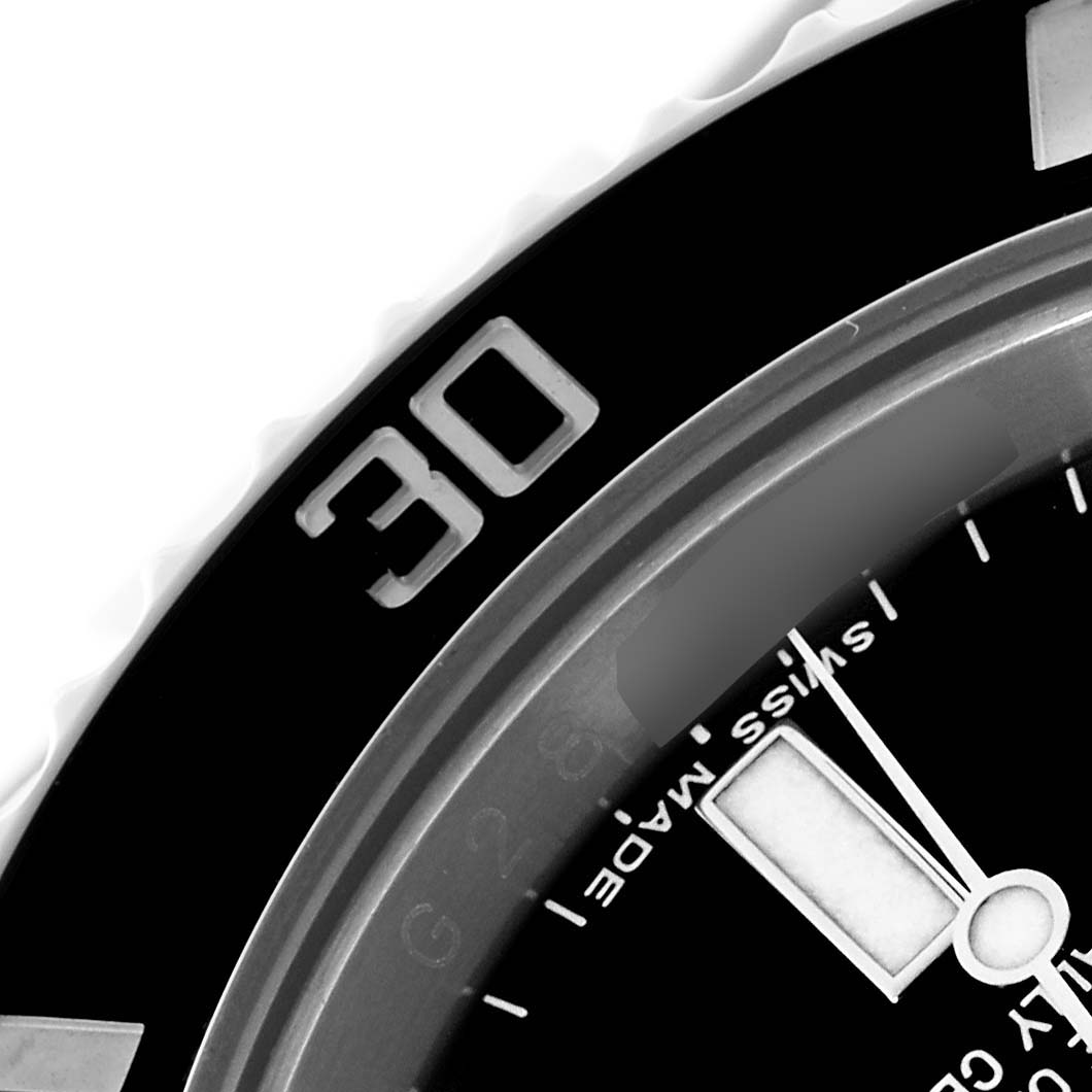 The image shows a close-up of a Rolex Submariner 116610 Men's Stainless Steel Black Dial 116610 Men's Stainless Steel Black Dial's bezel, partial dial, and minute hand.