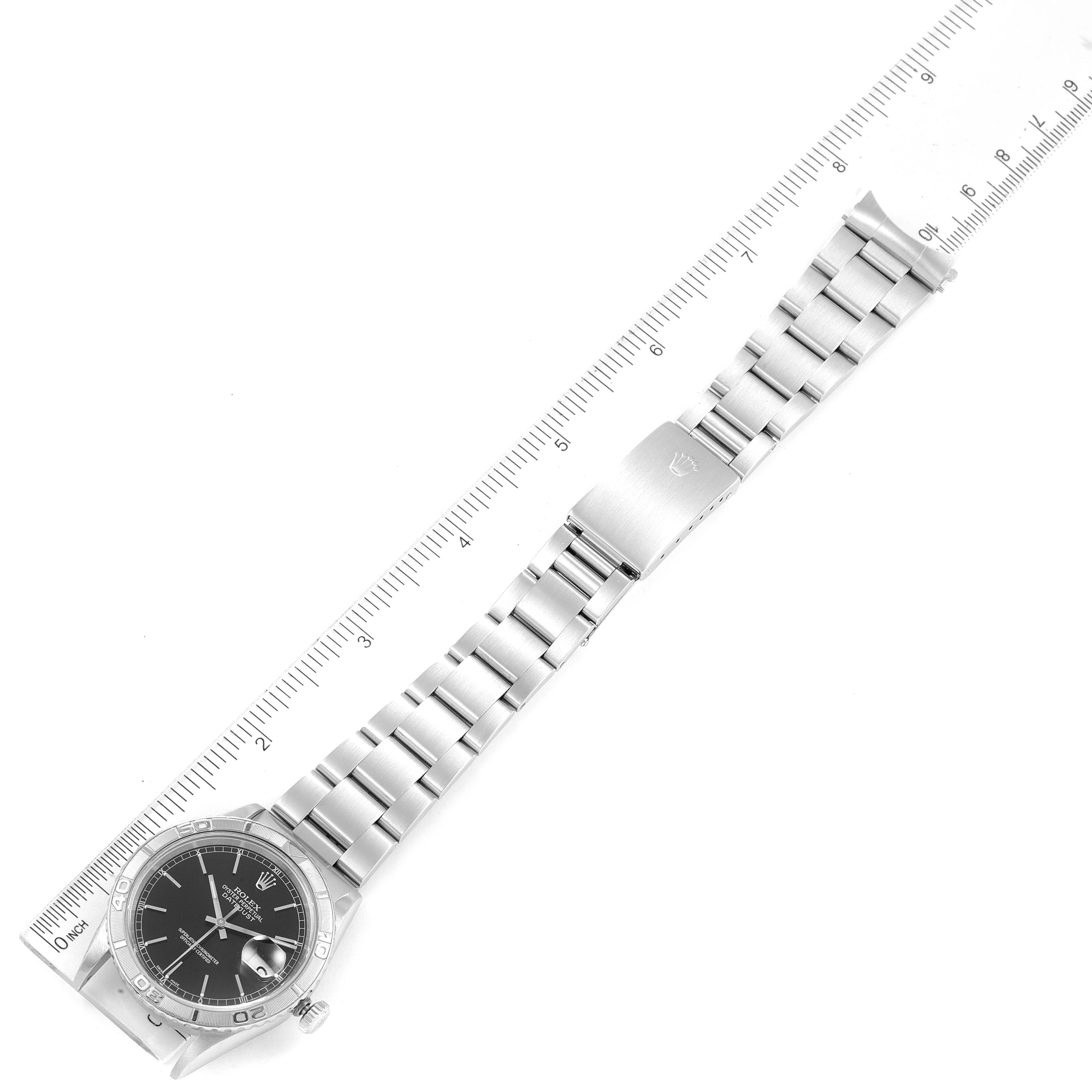 The image shows a top view of a Rolex Turn-o-Graph 16264 Men's Stainless Steel Black Dial 16264 Men's Stainless Steel Black Dial watch, displaying its face, bezel, bracelet, and clasp next to a ruler.
