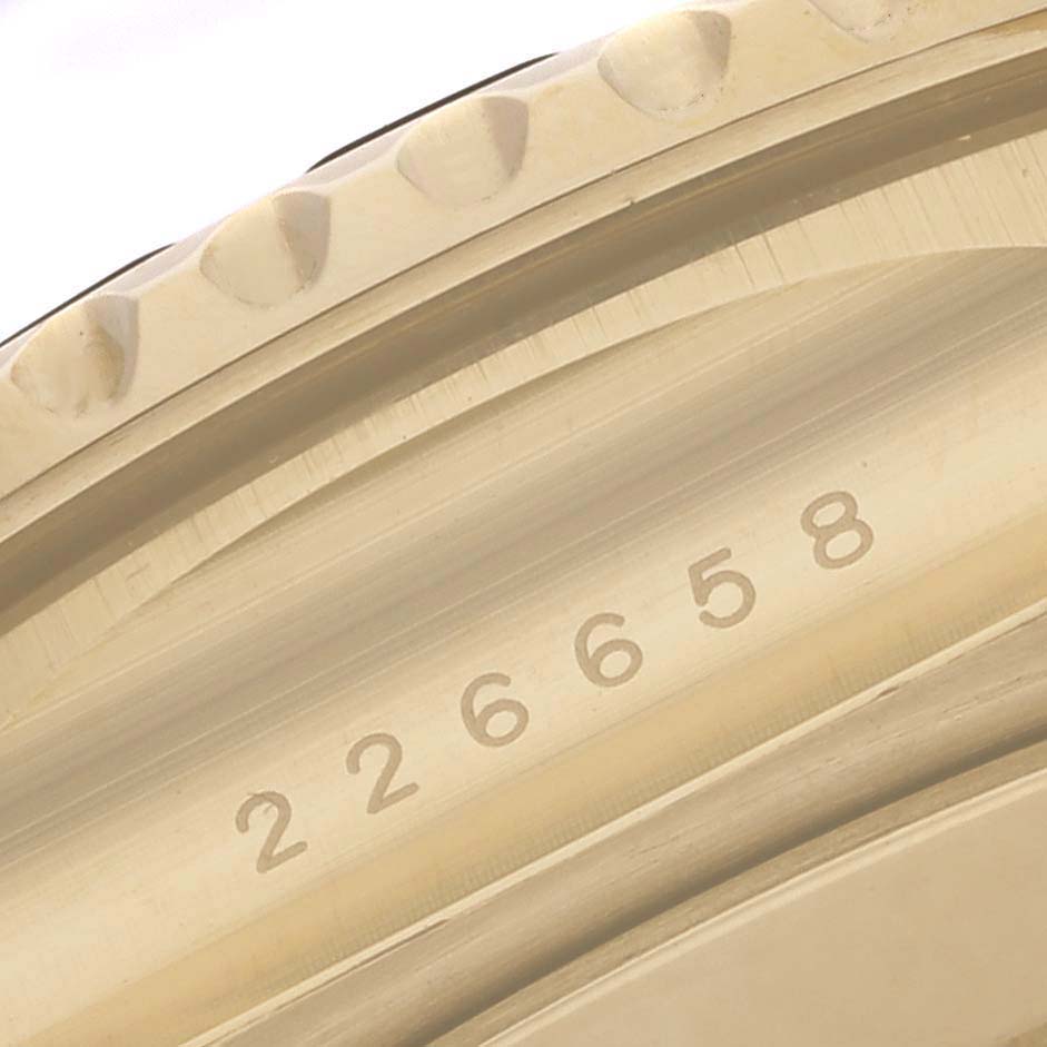 The image shows a close-up of the textured bezel and engraved serial number of a Rolex Yacht-Master 226658 Men's Yellow Gold Black Dial 226658 Men's Yellow Gold Black Dial watch.