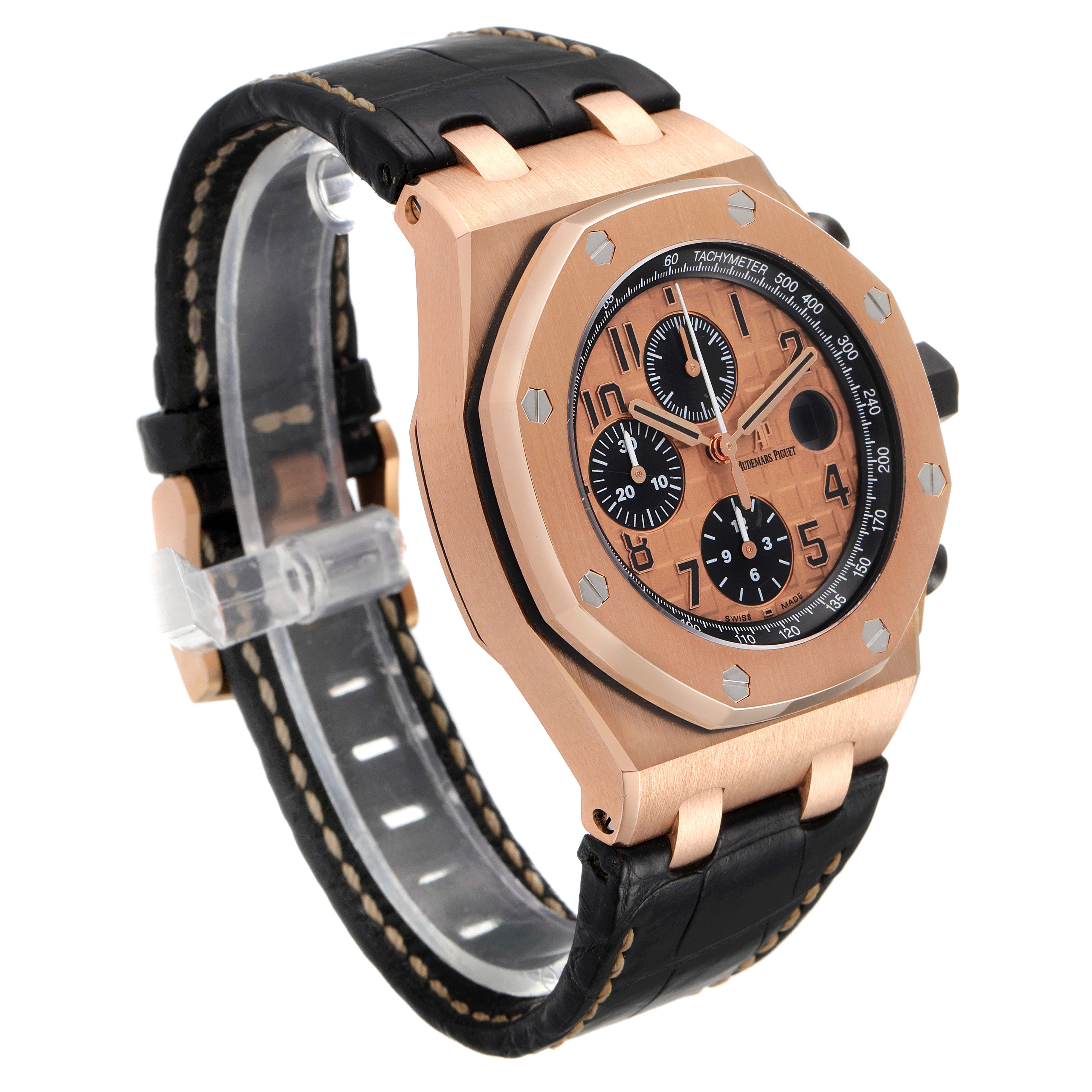 The image shows a side angle of an Audemars Piguet Royal Oak Offshore 26470OR.OO.A002CR.01 Men's Rose Gold Pink Dial 26470OR.OO.A002CR.01 Men's Rose Gold Pink Dial watch, highlighting its dial, case, and leather strap.