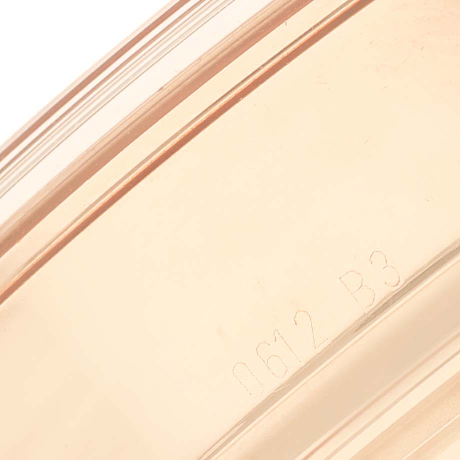 This close-up image shows the side of the case of a Breitling Transocean RB0510 Men's Rose Gold White Dial RB0510 Men's Rose Gold White Dial watch, highlighting engraved details.