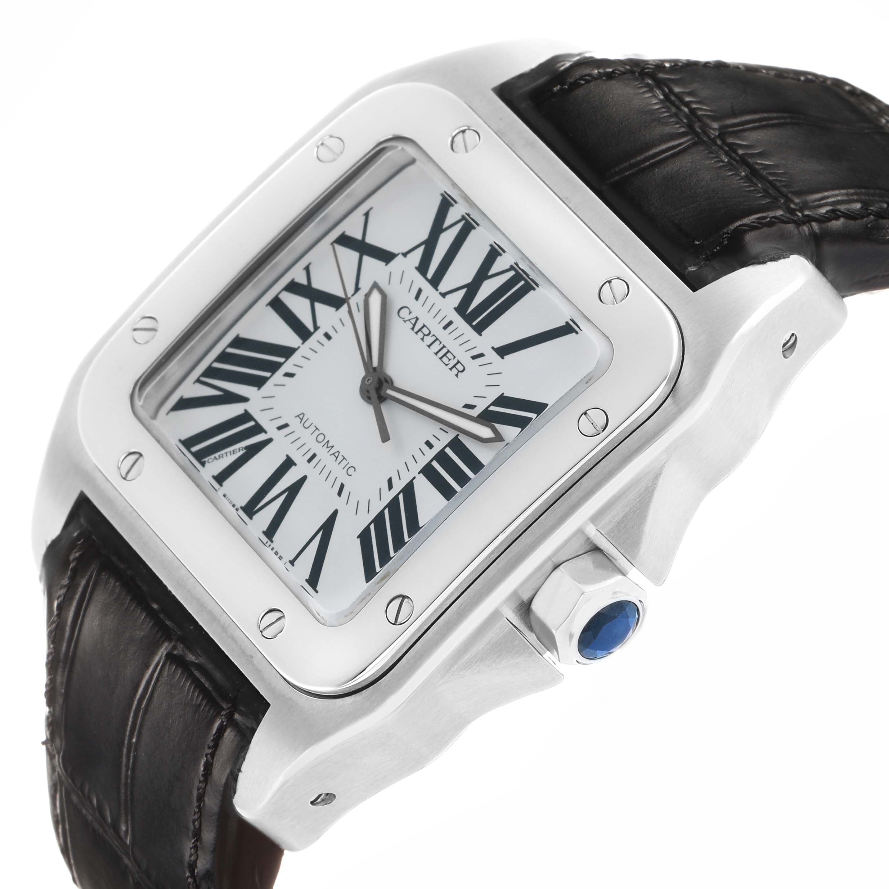 The Cartier Santos W20073X8 Men's Stainless Steel Silver Dial watch is shown at an angle highlighting the face, bezel, crown with blue cabochon, and leather strap.