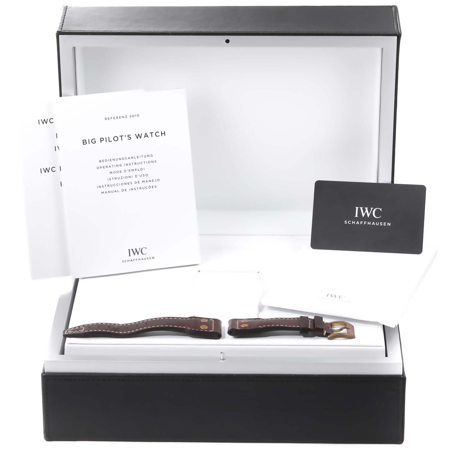 The image showcases the IWC Pilot IW501005 Men
s Bronze Black Dial IW501005 Men
s Bronze Black Dial model watch box containing its accessories, including manuals and additional watch straps.