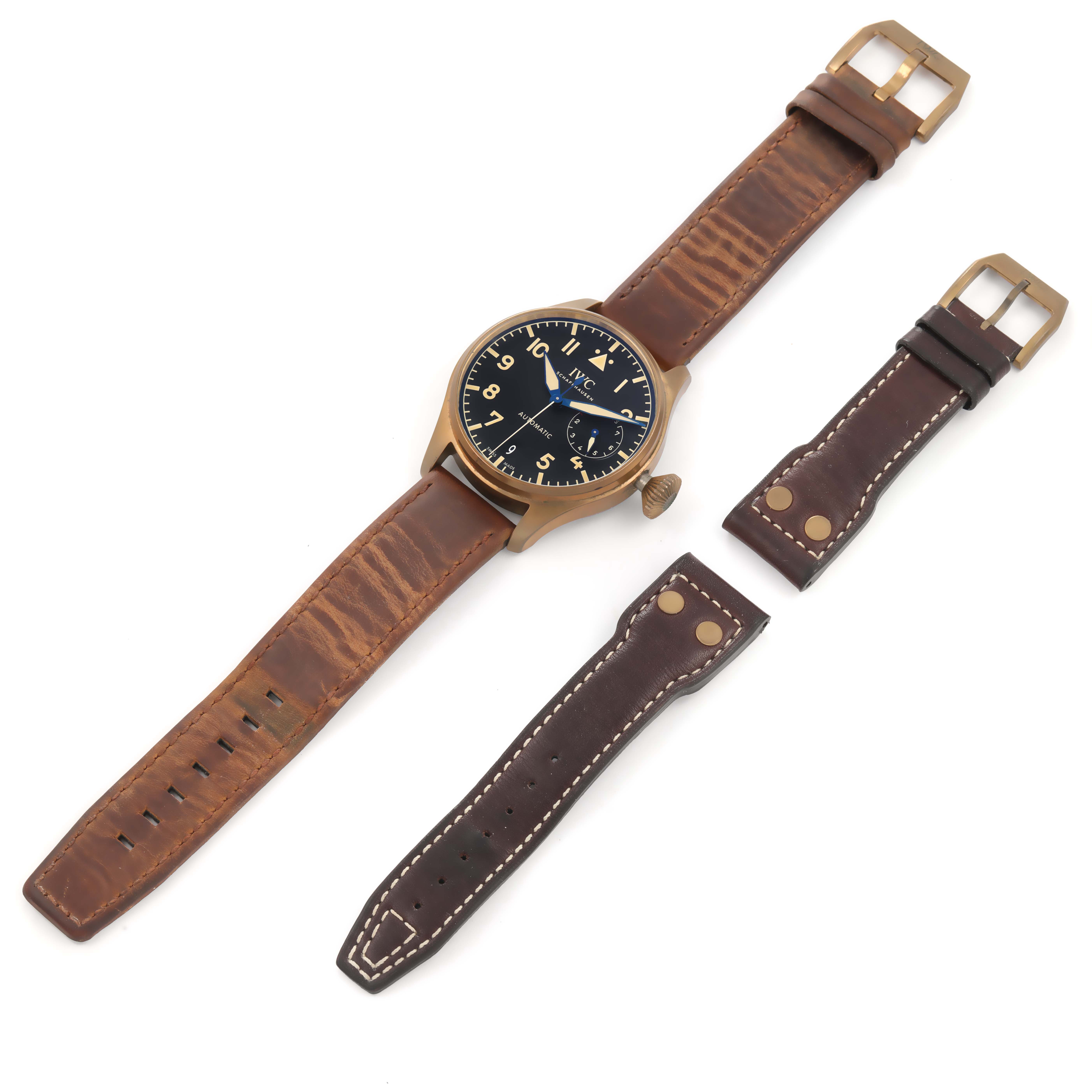 The image shows an IWC Pilot IW501005 Men
s Bronze Black Dial IW501005 Men
s Bronze Black Dial model watch with a brown leather strap and two additional brown leather straps.
