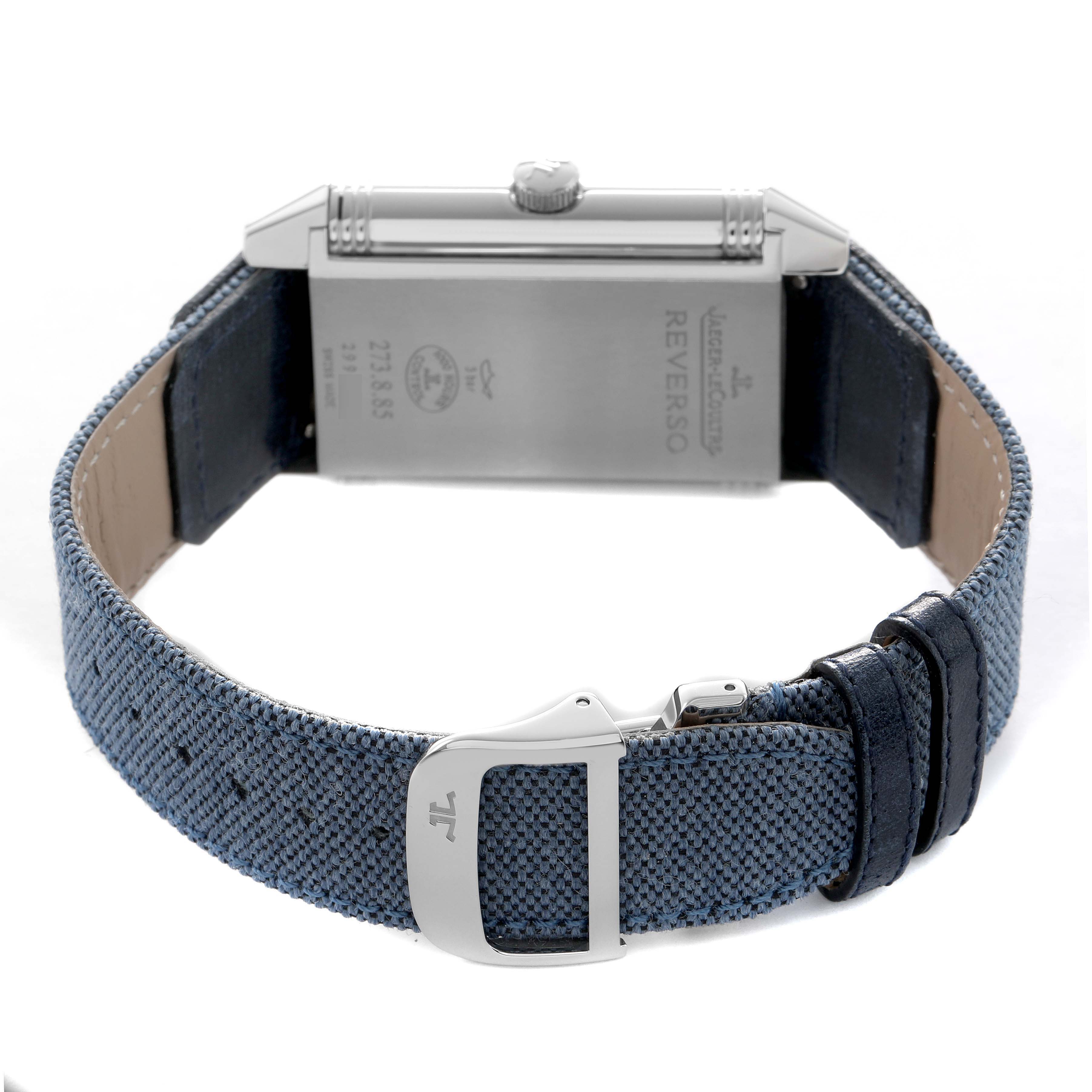 The image shows the back view of a Jaeger LeCoultre Reverso Q3748421 Men's Stainless Steel Silver Dial watch, highlighting the case back and blue fabric strap with a clasp.
