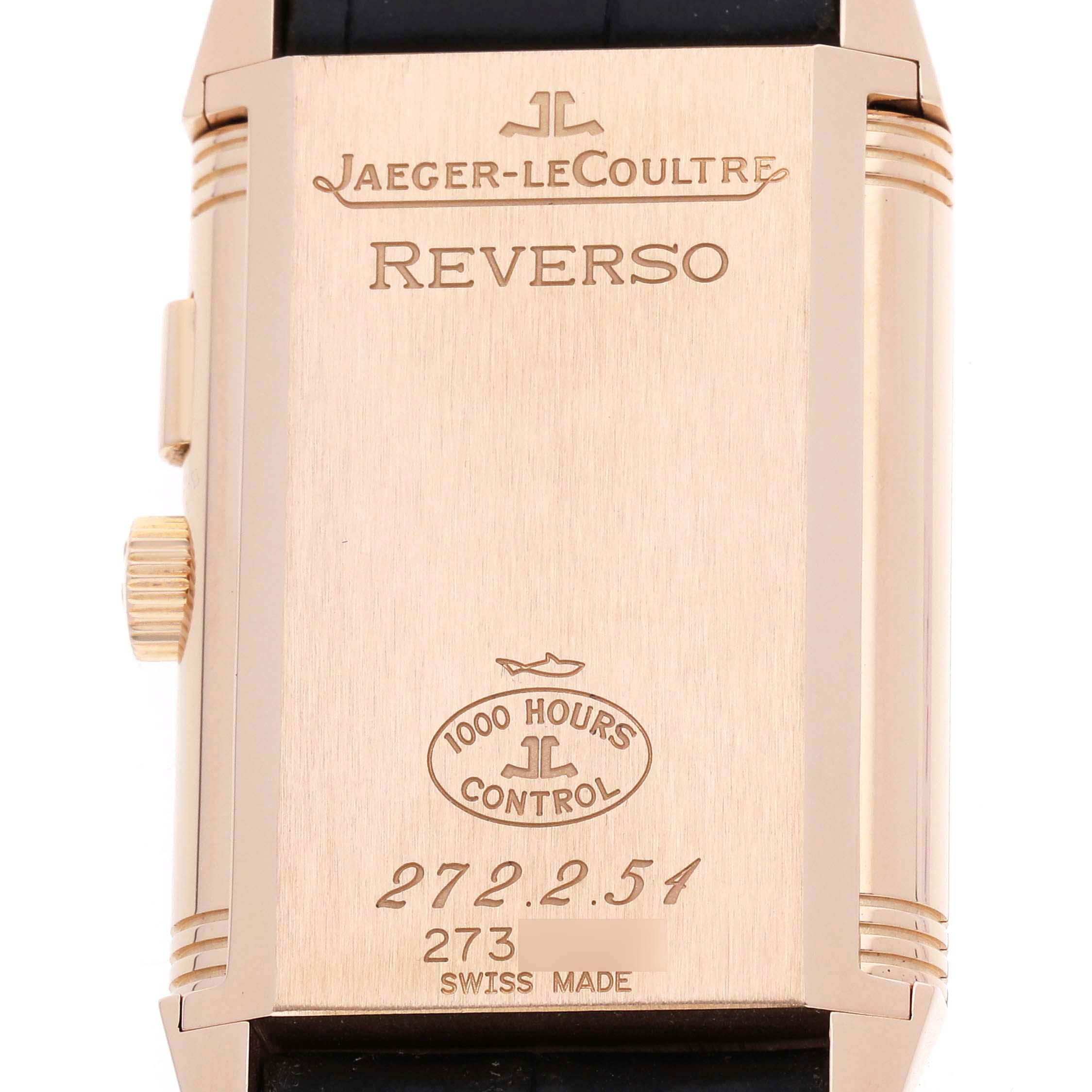 The image shows the back of a Jaeger-LeCoultre Reverso watch, displaying its engravings and a side view of the crown.