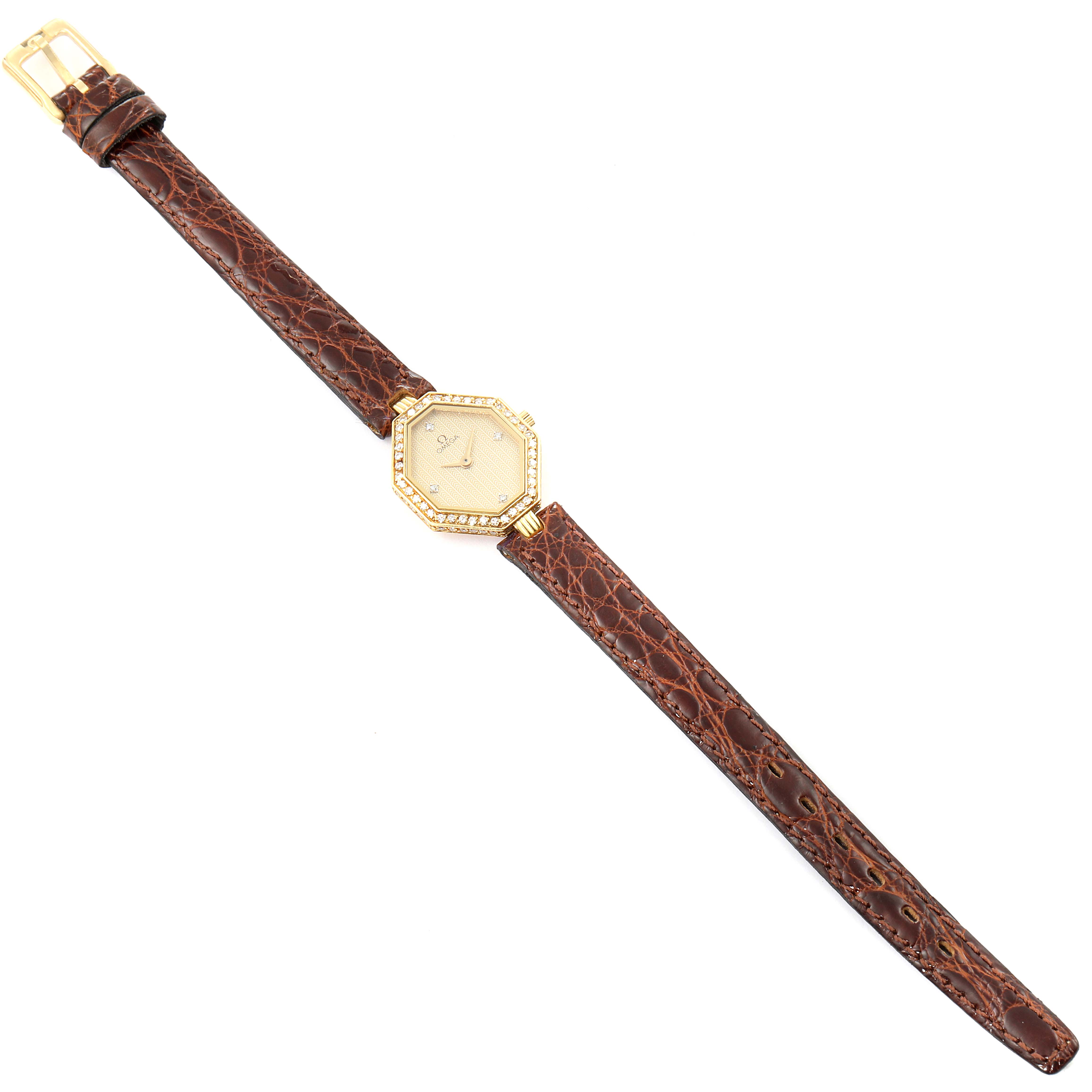 The image shows an overhead view of the Omega 1450 Women
s Yellow Gold Champagne Dial 1450 Women
s Yellow Gold Champagne Dial DeVille Mini Yellow Gold Diamond Cocktail Ladies Watch 1450 model, showcasing its face and brown leather strap.