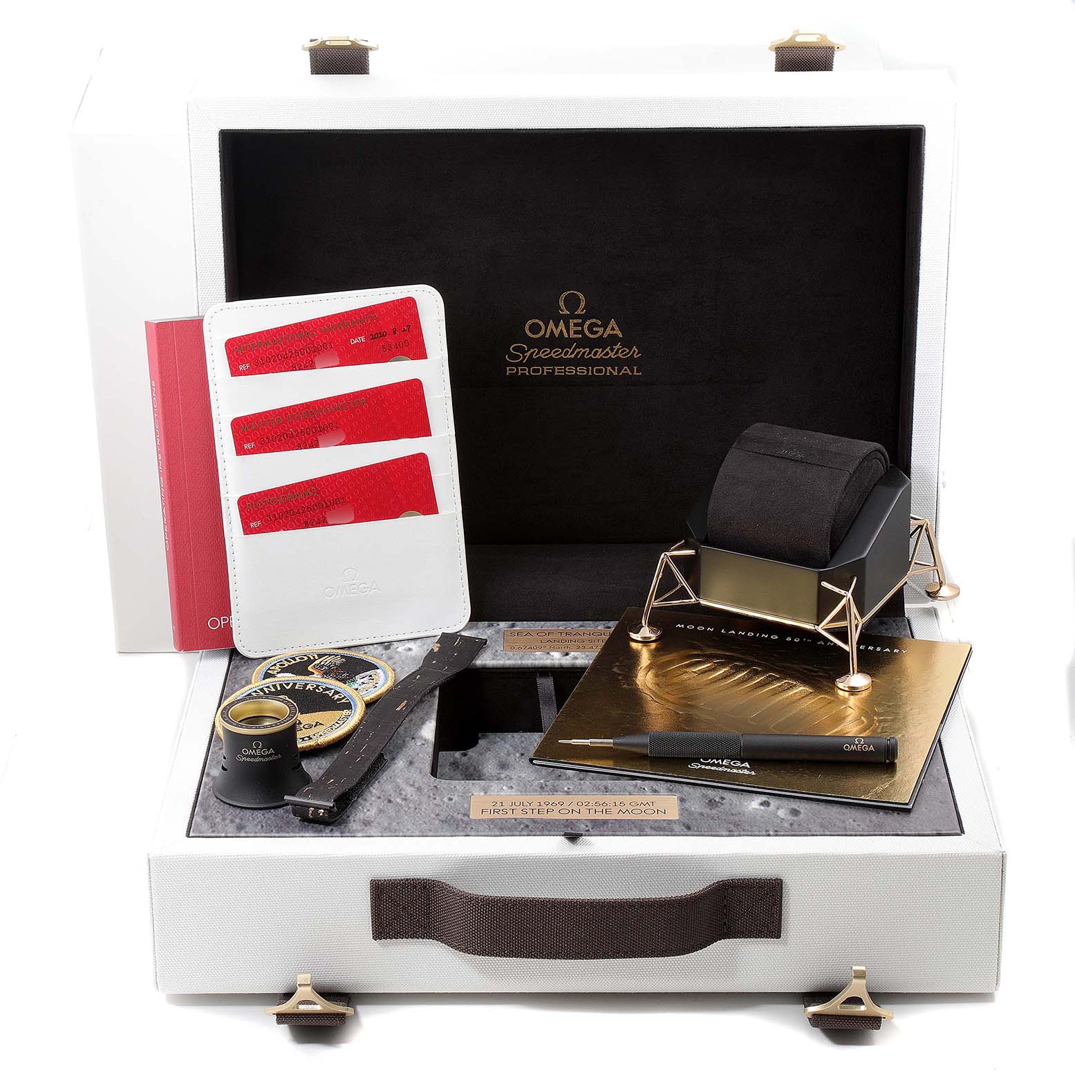 The image shows a box set for the Omega Speedmaster 310.20.42.50.01.001 Men's Stainless Steel Grey Dial 310.20.42.50.01.001 Men's Stainless Steel Grey Dial, including a watch stand, identification cards, a loupe, and additional accessories.