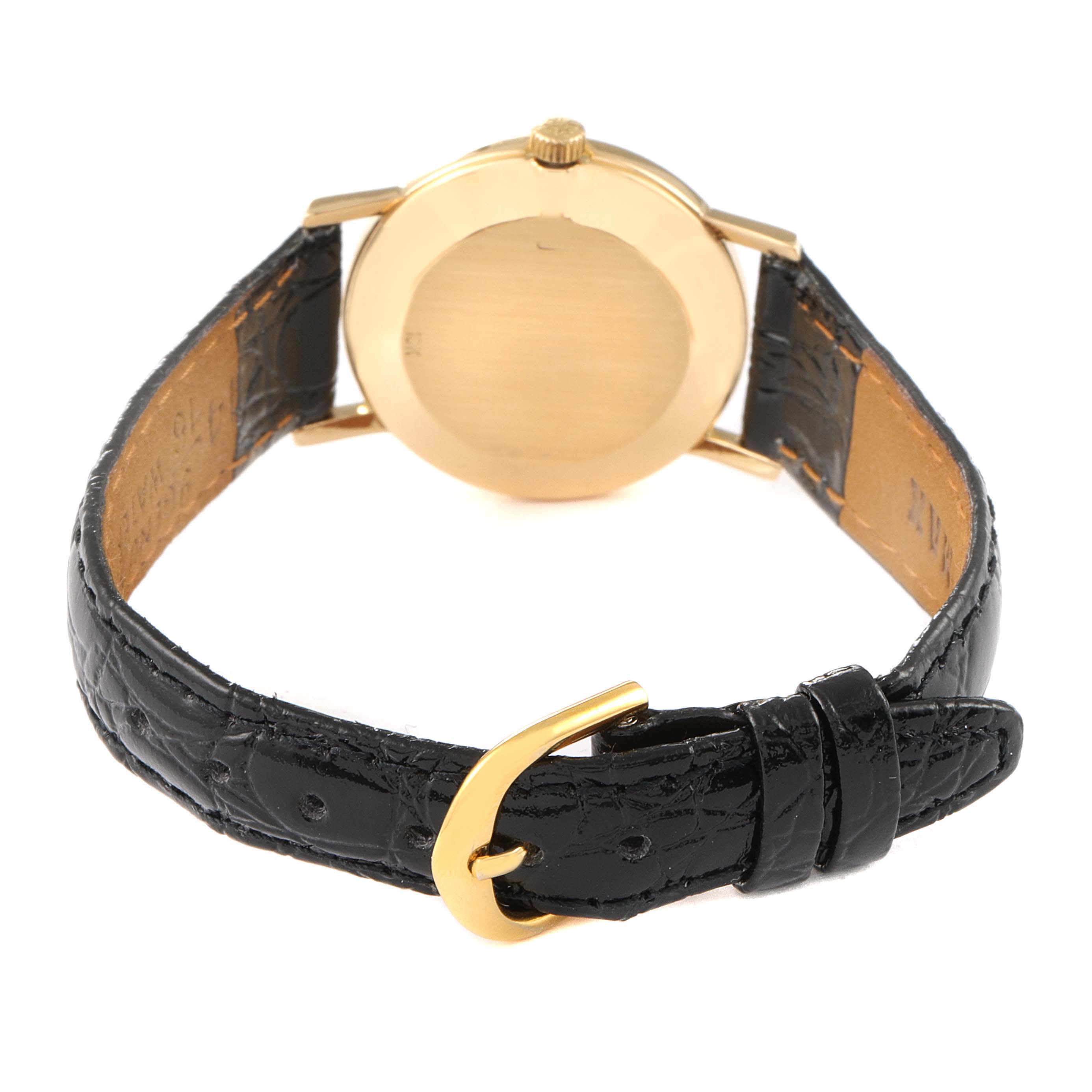 The image shows the back of a Patek Philippe Calatrava 4184J Women's Yellow Gold Silver Dial 4184J Women's Yellow Gold Silver Dial watch, highlighting the watch case, crown, and black leather strap with a buckle.