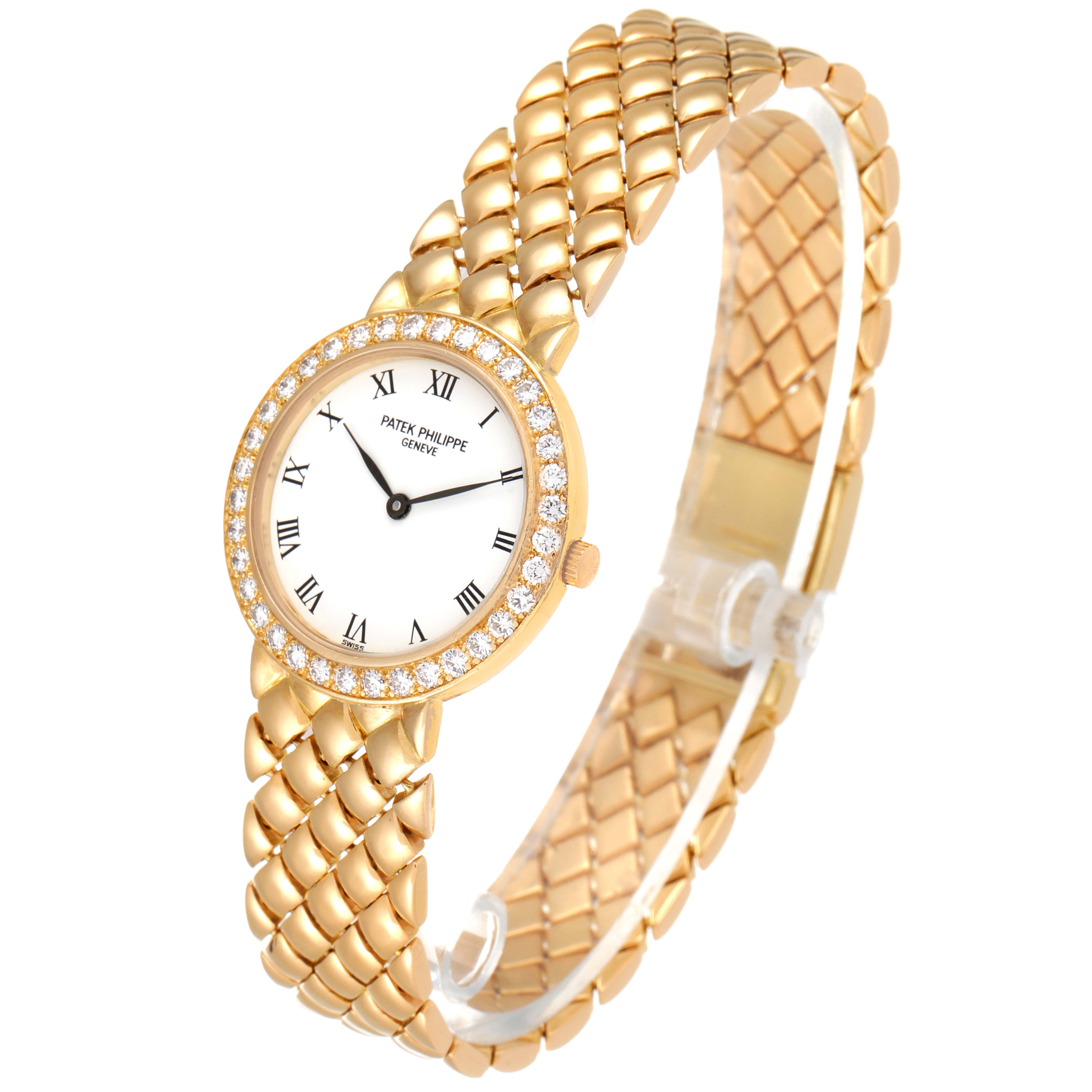 The image shows a close-up angle of a Patek Philippe Calatrava 4820 Women's Yellow Gold White Dial 4820 Women's Yellow Gold White Dial watch, highlighting its gold bracelet, diamond bezel, and Roman numeral dial.