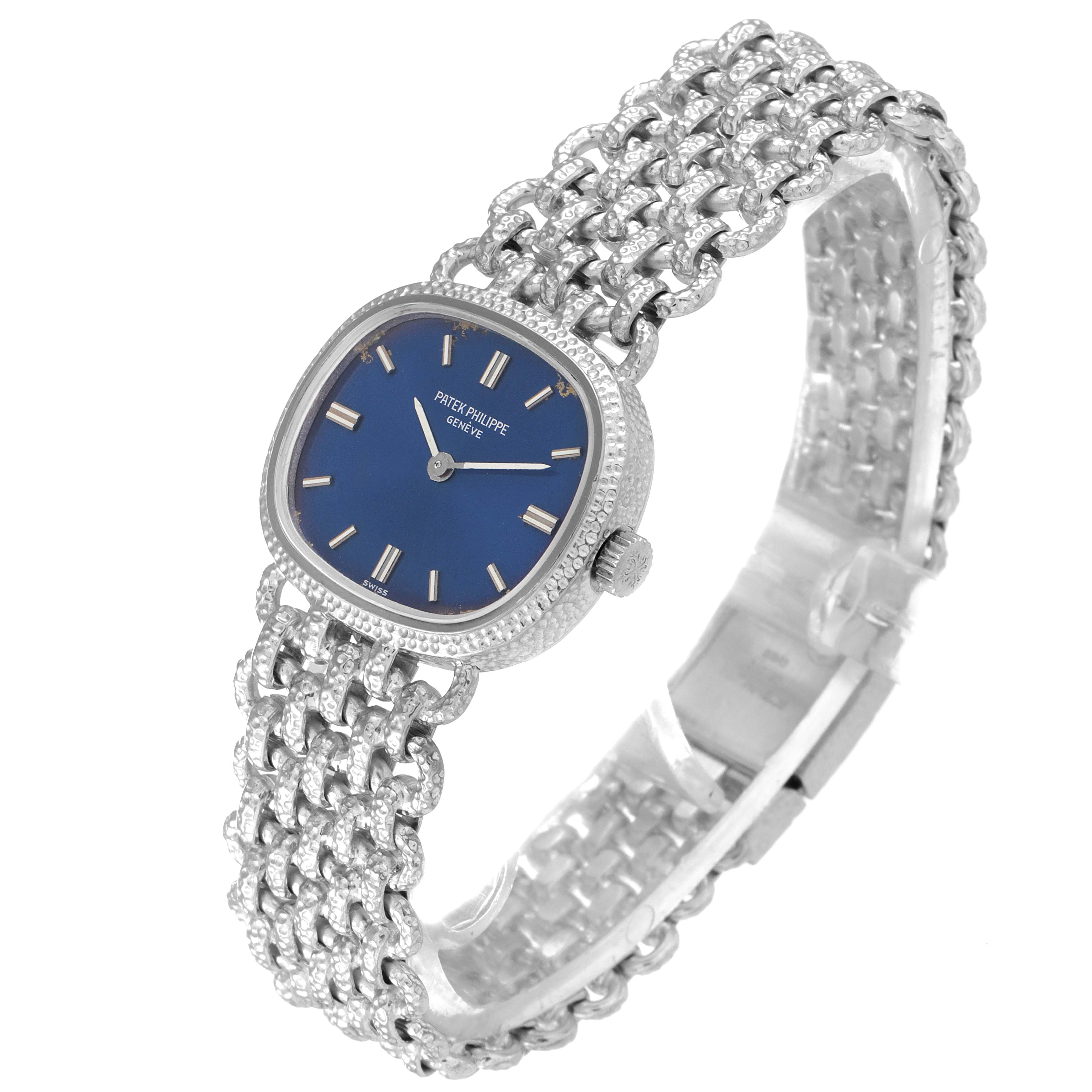 The image shows a side and front angle view of the Patek Philippe Golden Ellipse 4133 Women's White Gold Blue Dial 4133 Women's White Gold Blue Dial watch, highlighting its blue dial and intricate metal band.