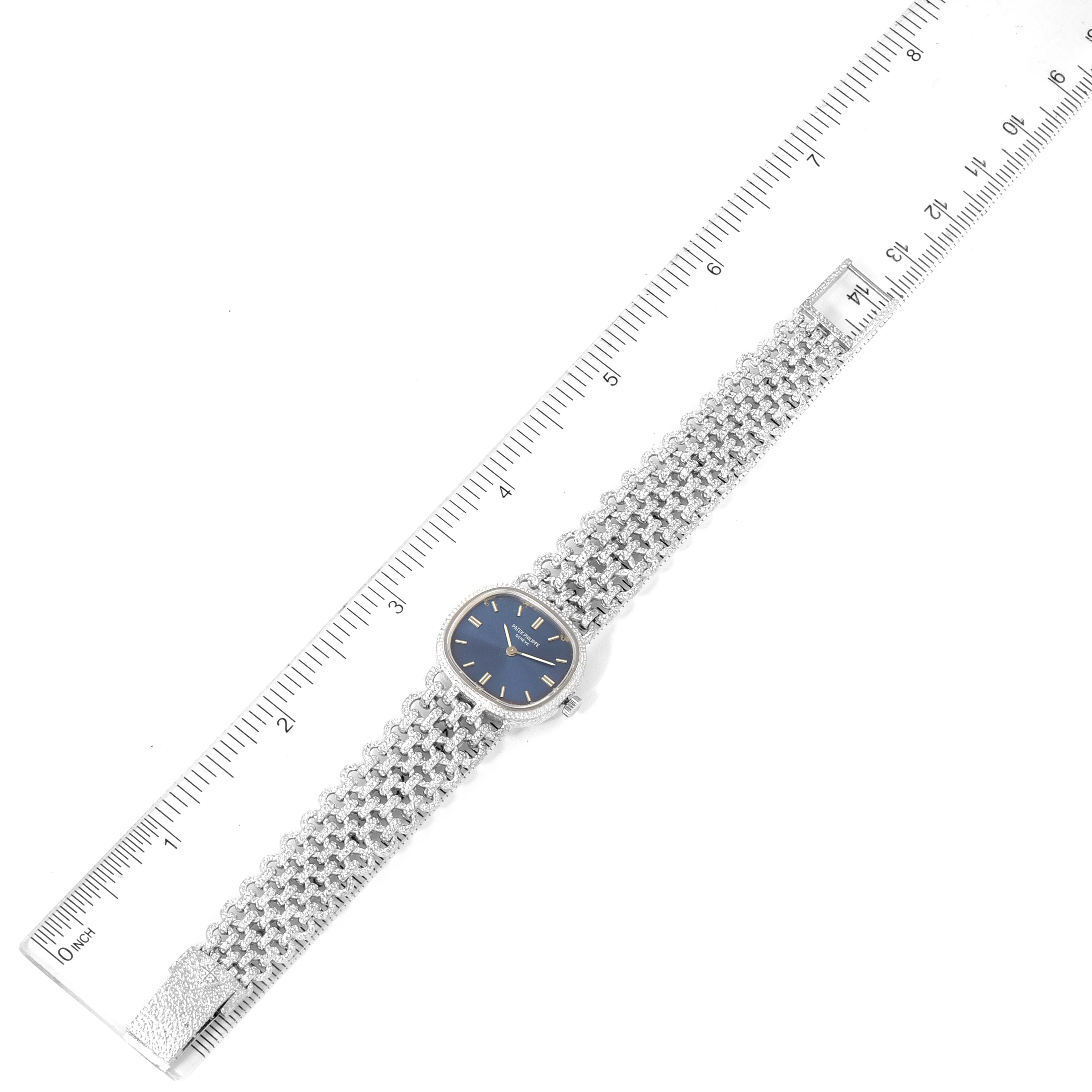 The Patek Philippe Golden Ellipse 4133 Women's White Gold Blue Dial 4133 Women's White Gold Blue Dial watch is shown laying flat, with the face, strap, and a ruler for scale in the image.