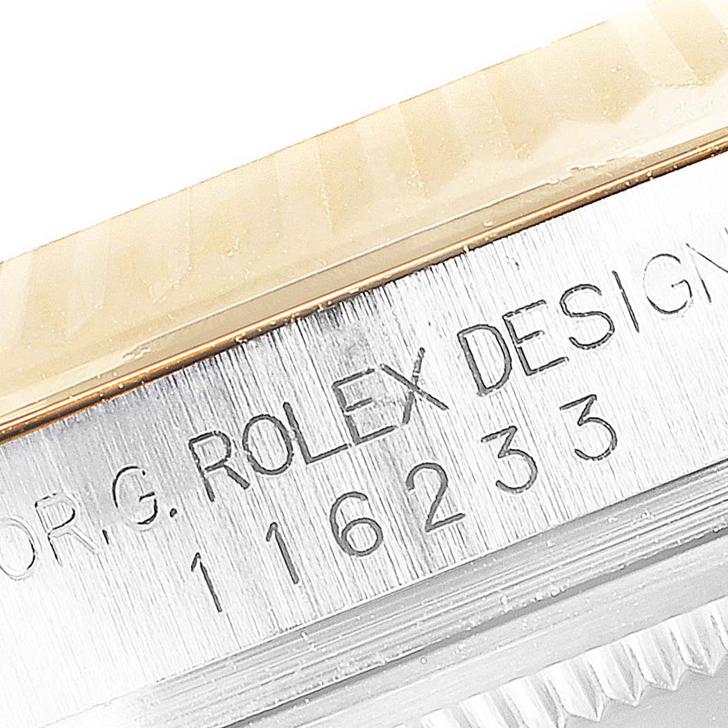 Close-up of a Rolex Datejust 116233 Men's Steel and Gold (two tone) Champagne Dial 116233 Men's Steel and Gold (two tone) Champagne Dial model showing the bezel and engraved model number 116233 on the metal case.