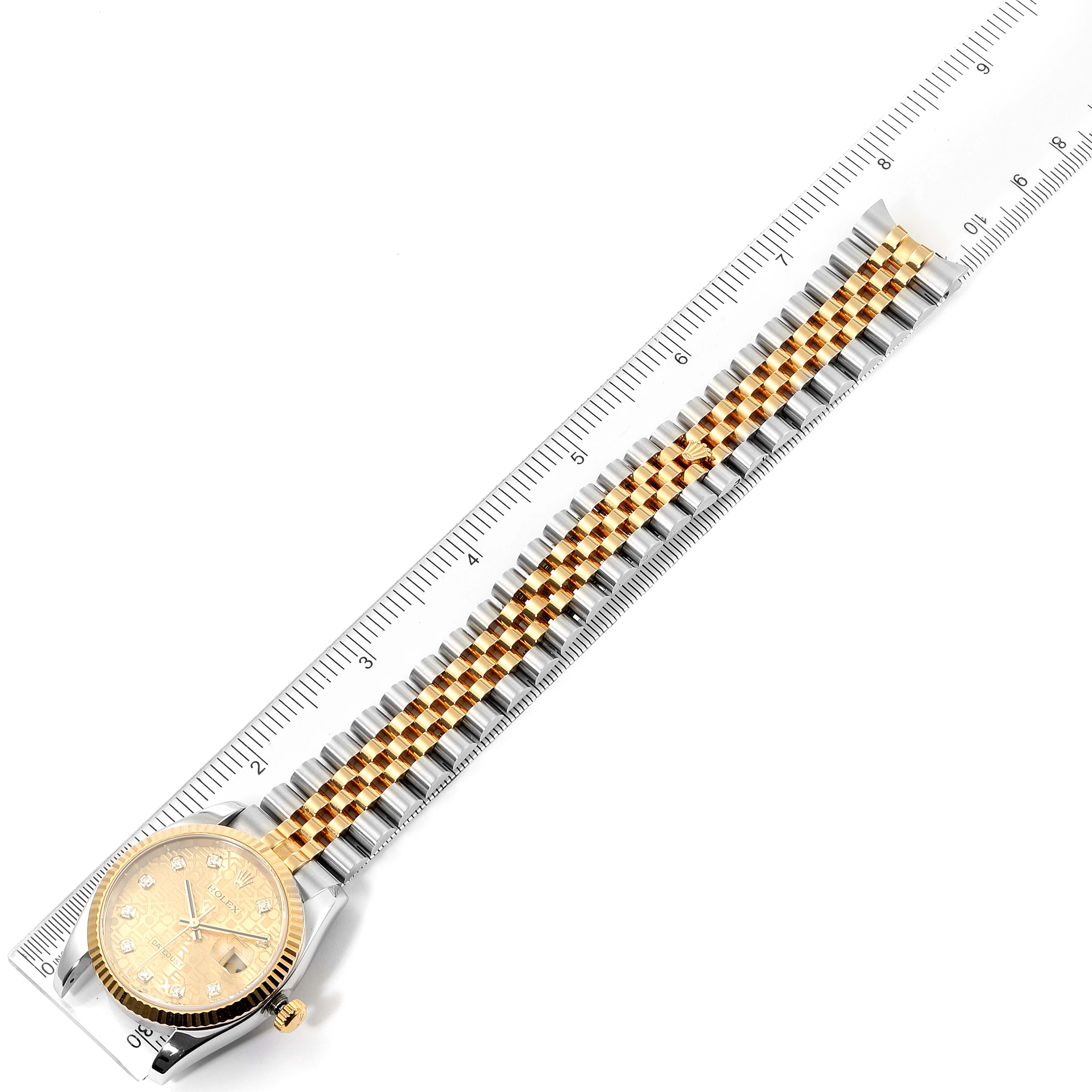 The Rolex Datejust 116233 Men's Steel and Gold (two tone) Champagne Dial 116233 Men's Steel and Gold (two tone) Champagne Dial watch is shown from a top-down angle, featuring the dial, crown, bracelet, and a ruler for scale.