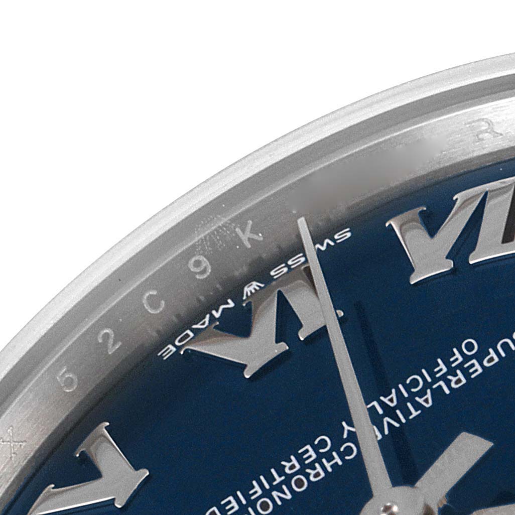 This close-up of a Rolex Mid-Size 278274 Women's Stainless Steel Blue Dial 278274 Women's Stainless Steel Blue Dial model watch shows part of the blue dial, Roman numerals, and minute hand.