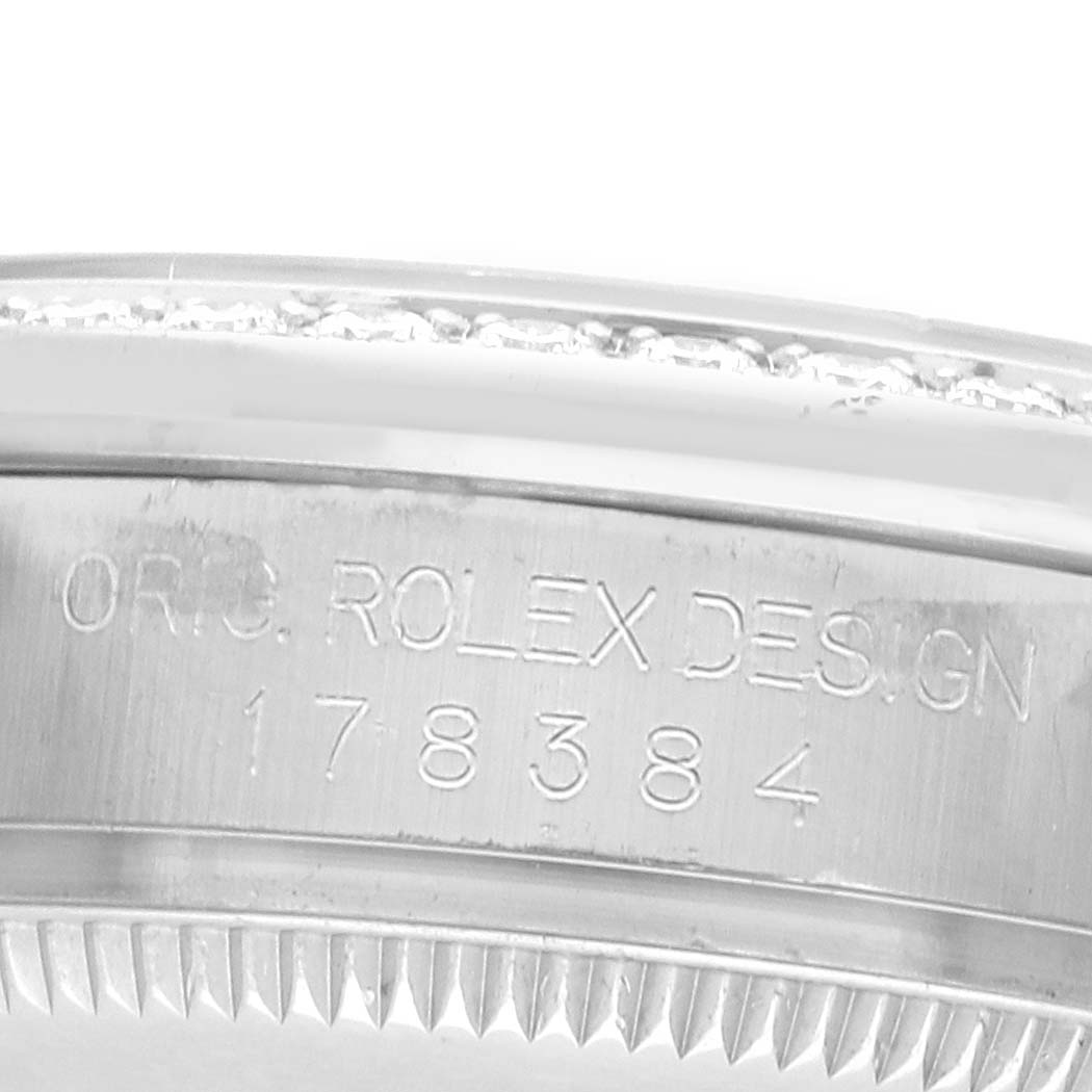 The image shows an angled close-up of the Rolex Datejust 178384 Women's Stainless Steel Mother of Pearl Dial model's bezel, featuring engraved text and fluted edges.