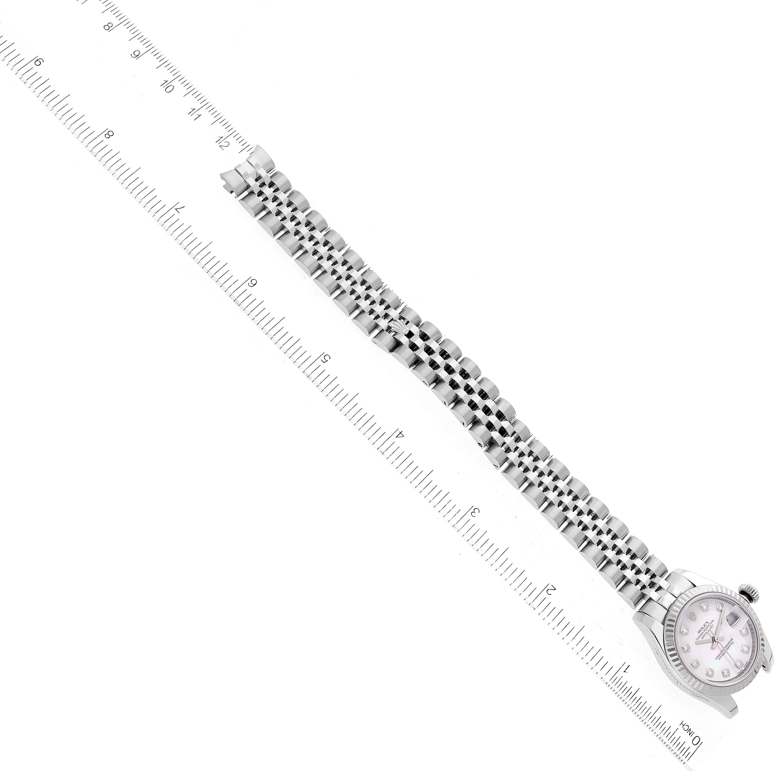 The image shows a top-down view of a Rolex Datejust 179174 Women's Stainless Steel Mother of Pearl Dial 179174 Women's Stainless Steel Mother of Pearl Dial watch, highlighting its face, bracelet, and part of a measuring ruler.