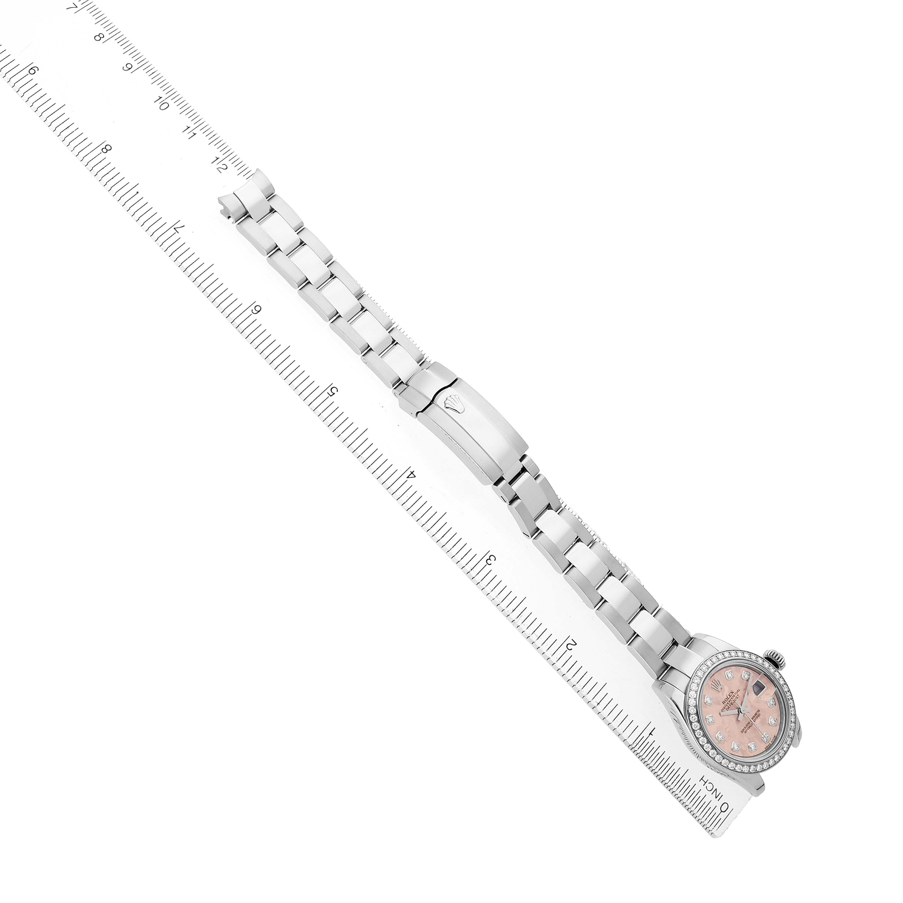 The image shows a Rolex Datejust 179384 Women's Stainless Steel Pink Dial watch with a pink dial, bracelet, and clasp, viewed from above, next to a ruler.