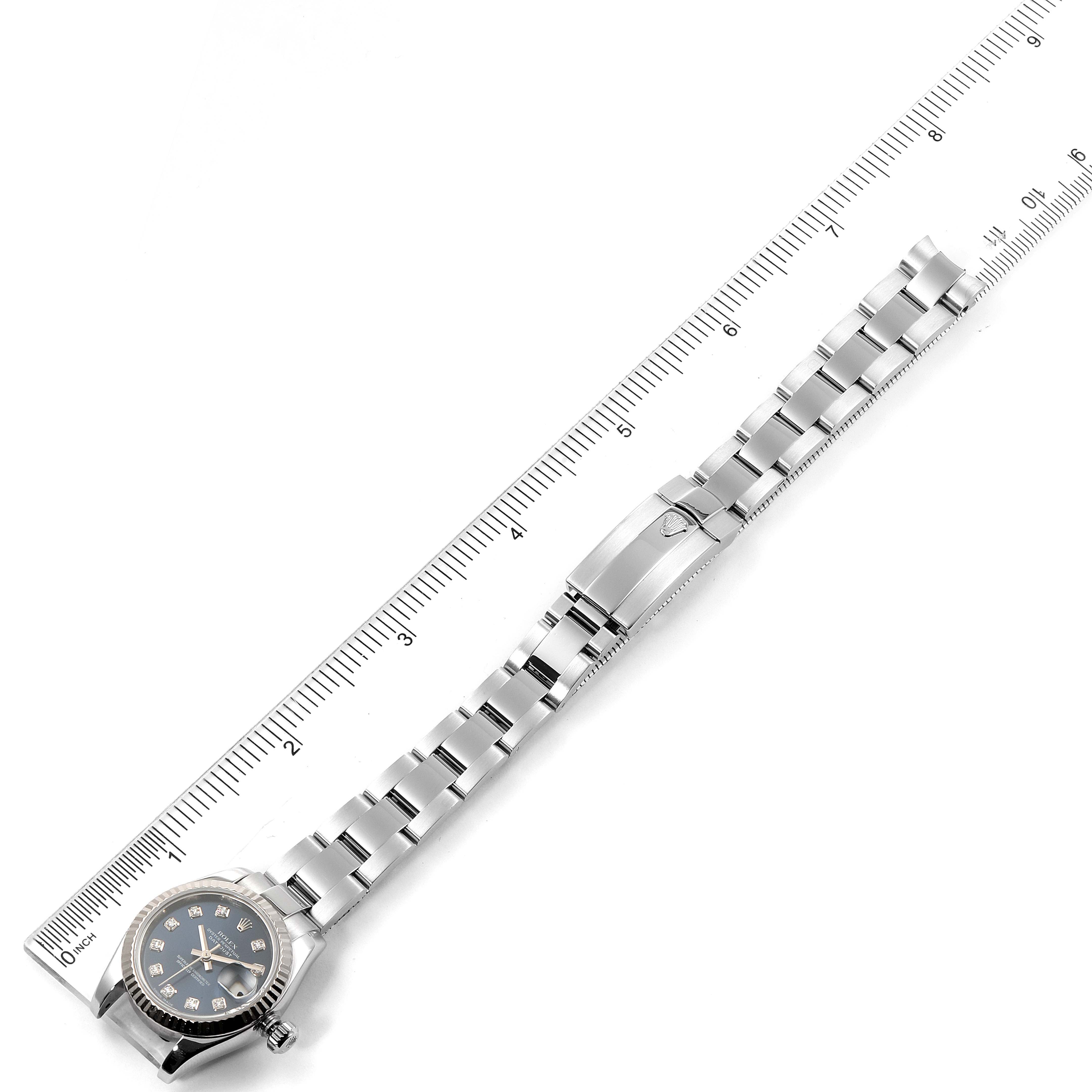 The Rolex Datejust 179174 Women's Stainless Steel Blue Dial 179174 Women's Stainless Steel Blue Dial watch is shown fully extended from an overhead angle, with the bracelet and clasp visible alongside a ruler for scale.