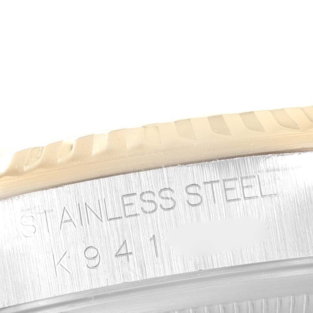 The image shows a close-up of the stainless steel bezel and engravings on the side of a Rolex Datejust 16233 Men's Steel and Gold (two tone) White Dial 16233 Men's Steel and Gold (two tone) White Dial watch.
