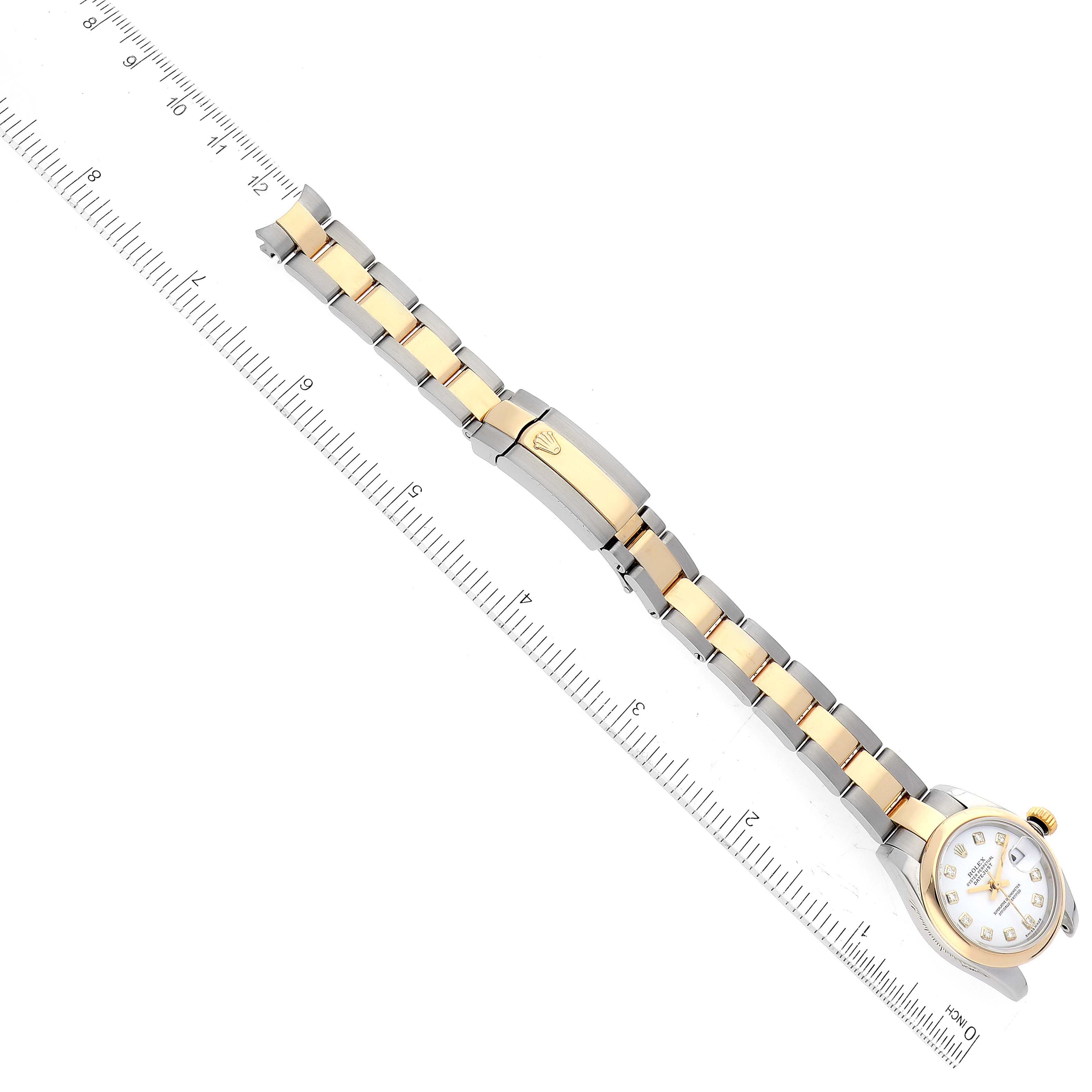The Rolex Datejust 179163 Women's Steel and Gold (two tone) White Dial 179163 Women's Steel and Gold (two tone) White Dial watch is shown from a top-down angle featuring the face, bezel, and the full two-tone bracelet alongside a ruler.
